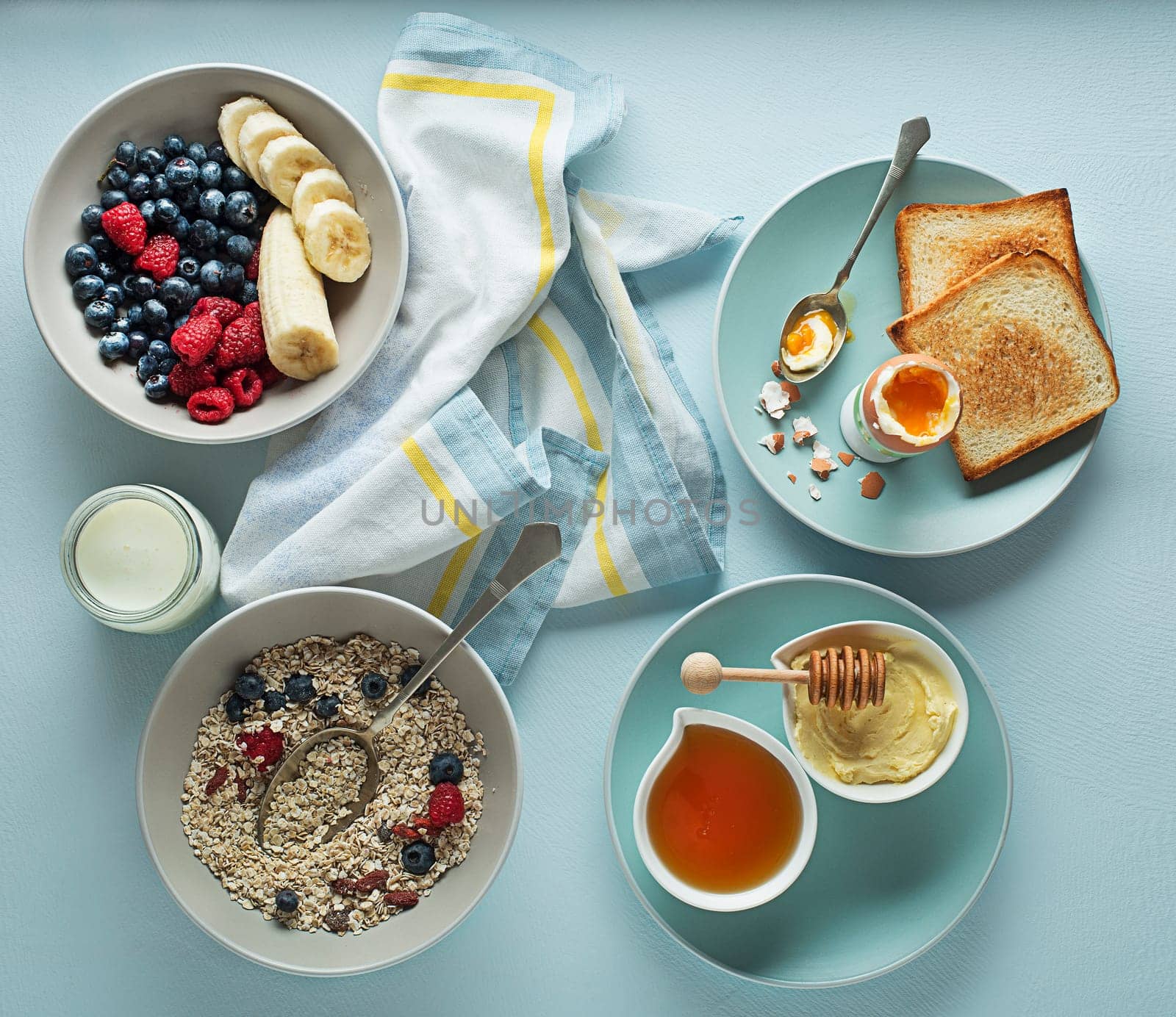Breakfast served with oatmeal and fruits, boiled egg, honey and butter. Delicious healthy breakfast.