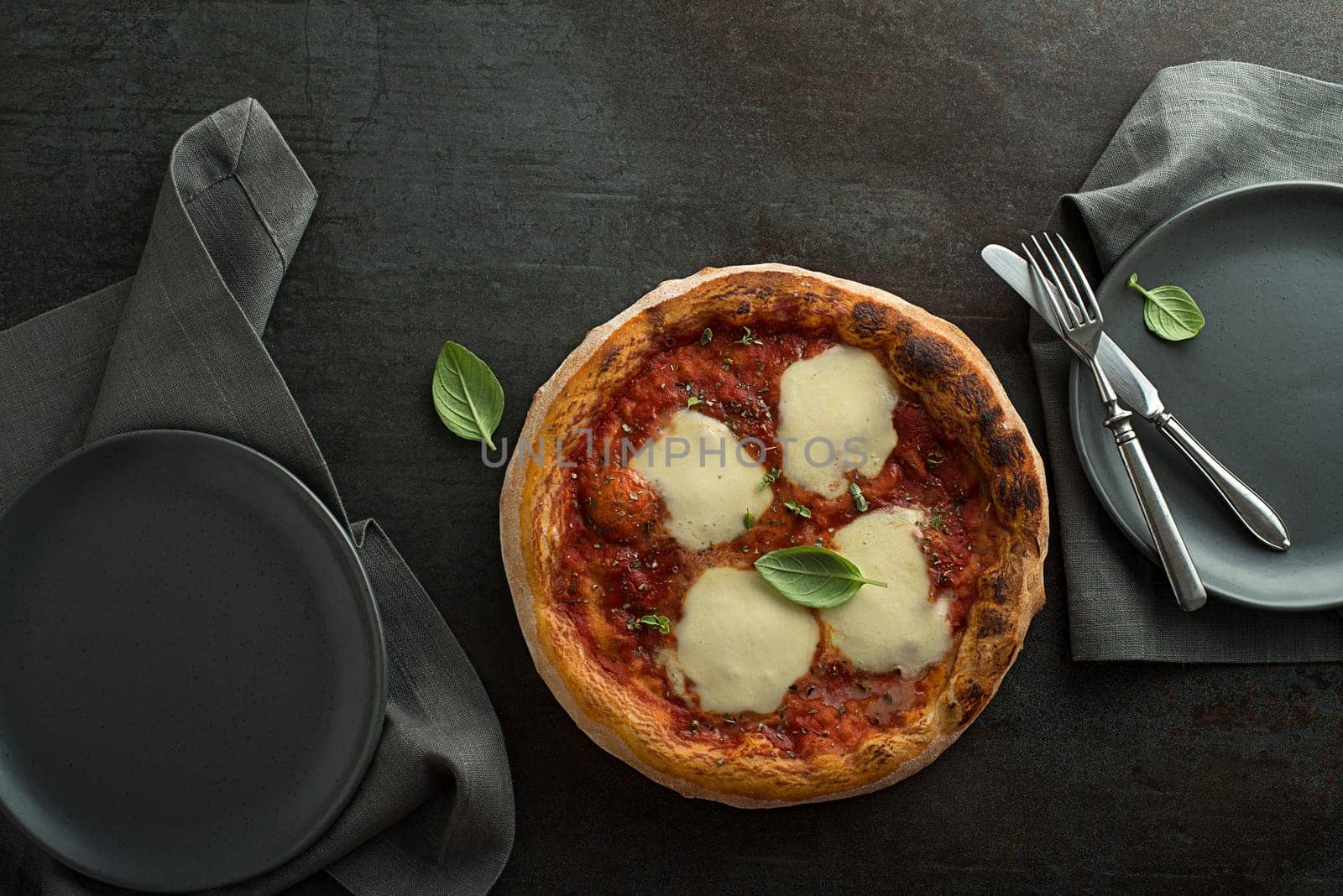 Pizza Margherita served with mozzarella cheese, tomato sauce and fresh basil