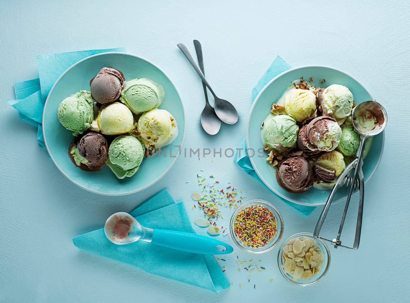 Variety of ice cream scoops with chocolate vanilla and fruity flavor scooped in plate with utensil