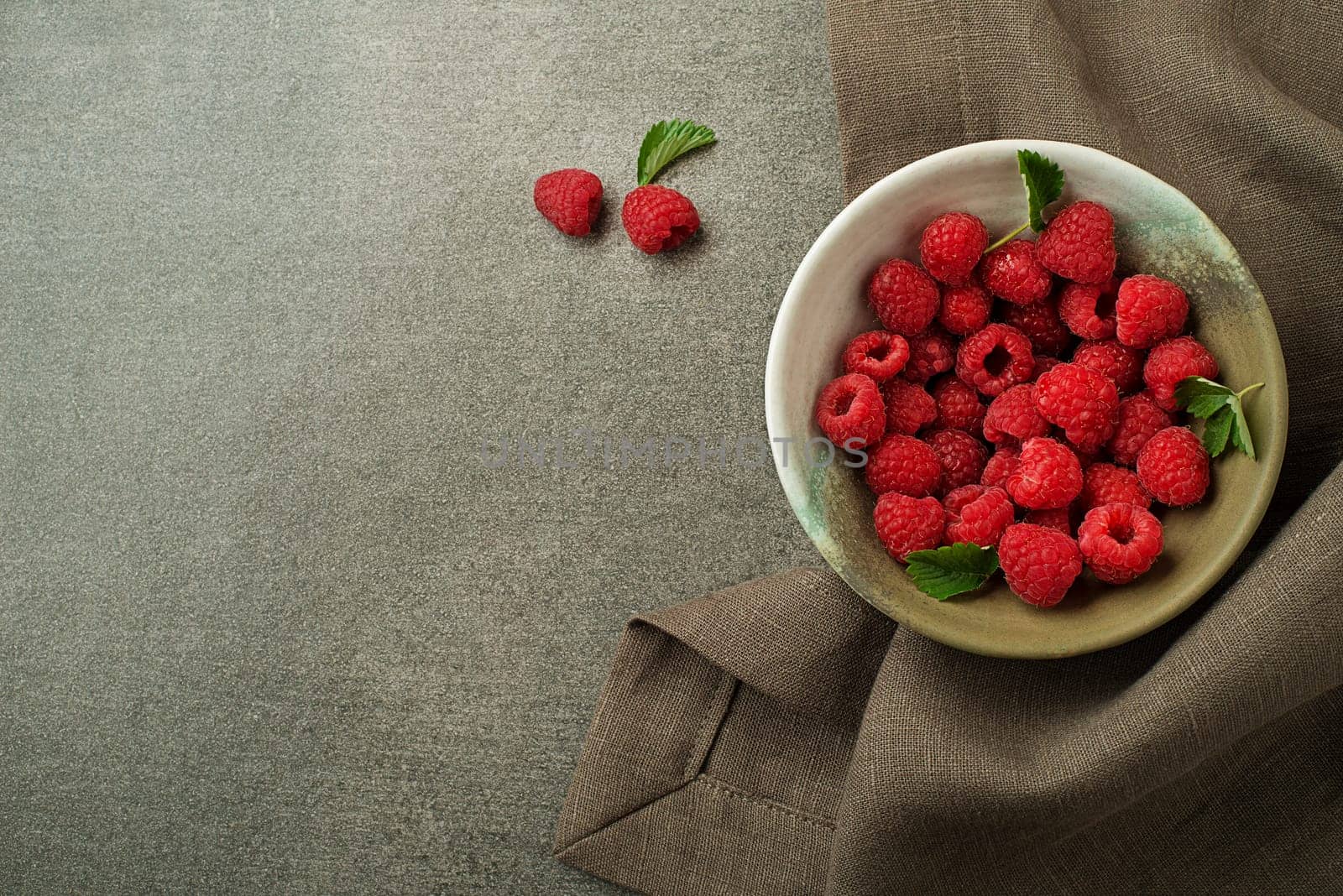 Raspberries with green leaf close up. Healthy food with fresh berry fruit.