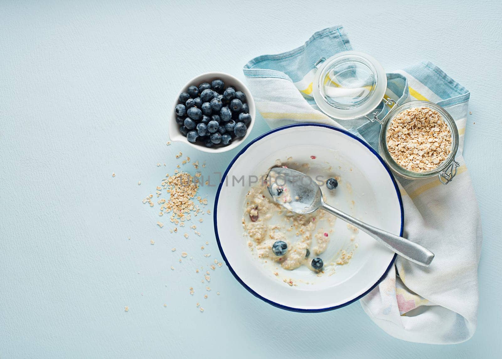 Eating porridge oatmeal with fruits, berries, and honey. Concept of healthy breakfast, wellbeing, healthy eating, dieting and weight loss