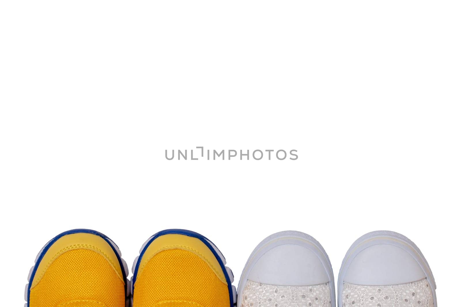 Top view on details of two colorful pairs shoes isolated on a white background. Sneaker fashion for kids. Space for design.