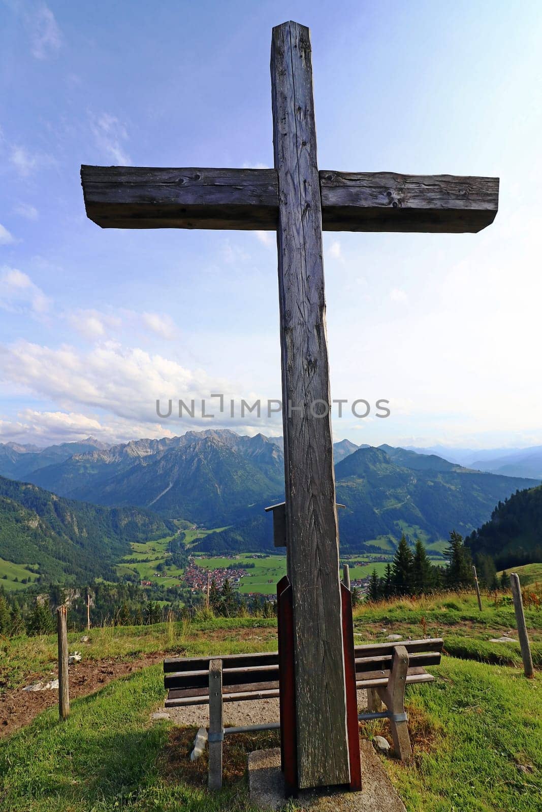 A summit cross in the Alps. A summit cross in the Allgaeu Alps. A summit cross in the evening light against the sky.