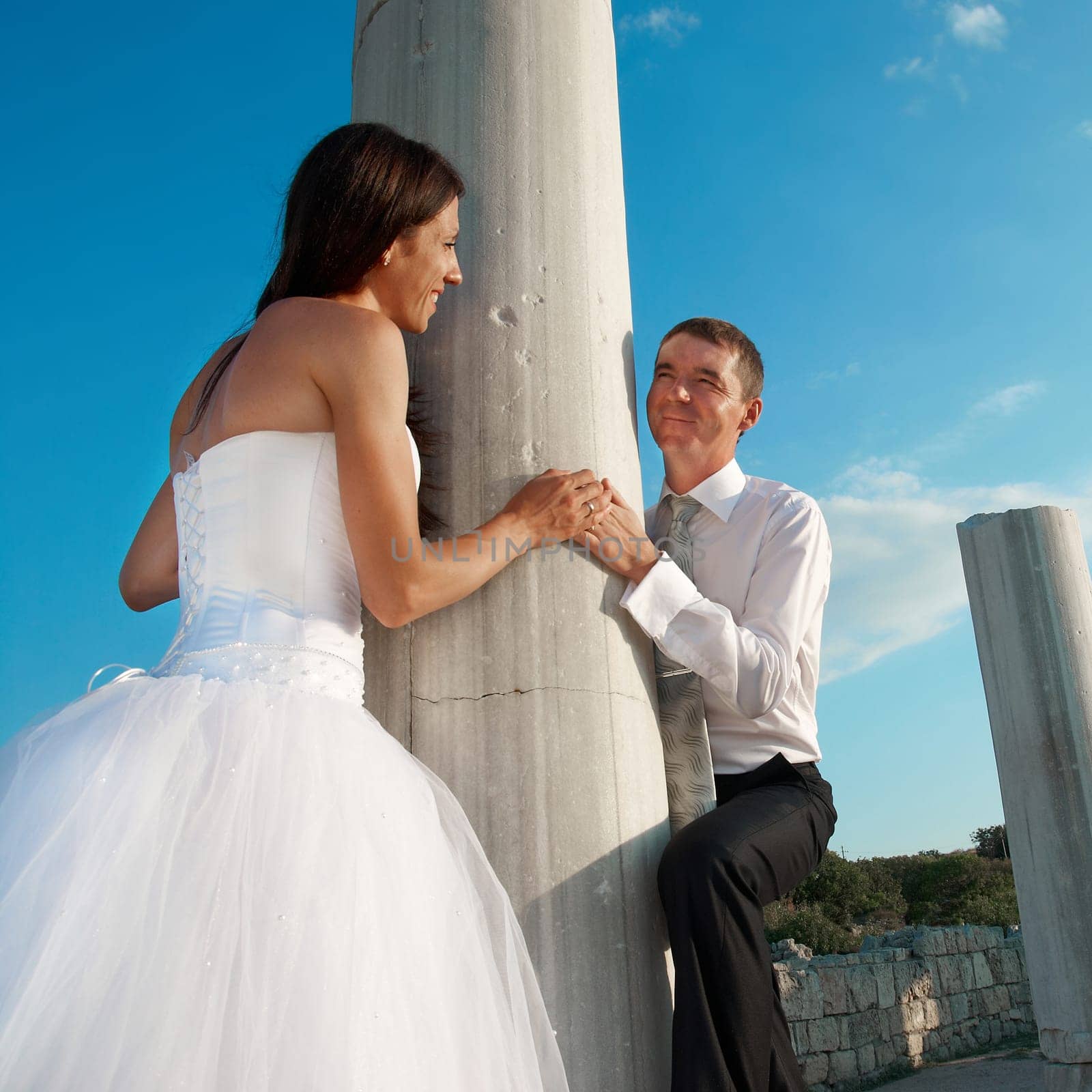 Beautiful wedding couple- bride and groom near greece column in the ancient city