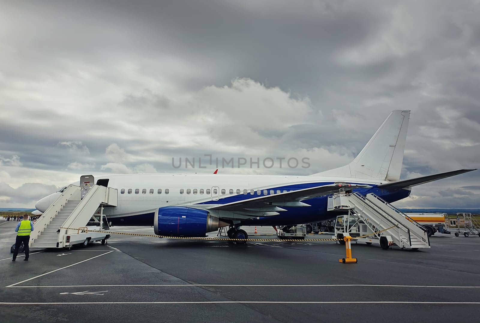Plane ready for boarding at airport in a cloudy day. Passenger transportation at Charles de Gaulle Airport in Paris. Travel and industry concepts.
