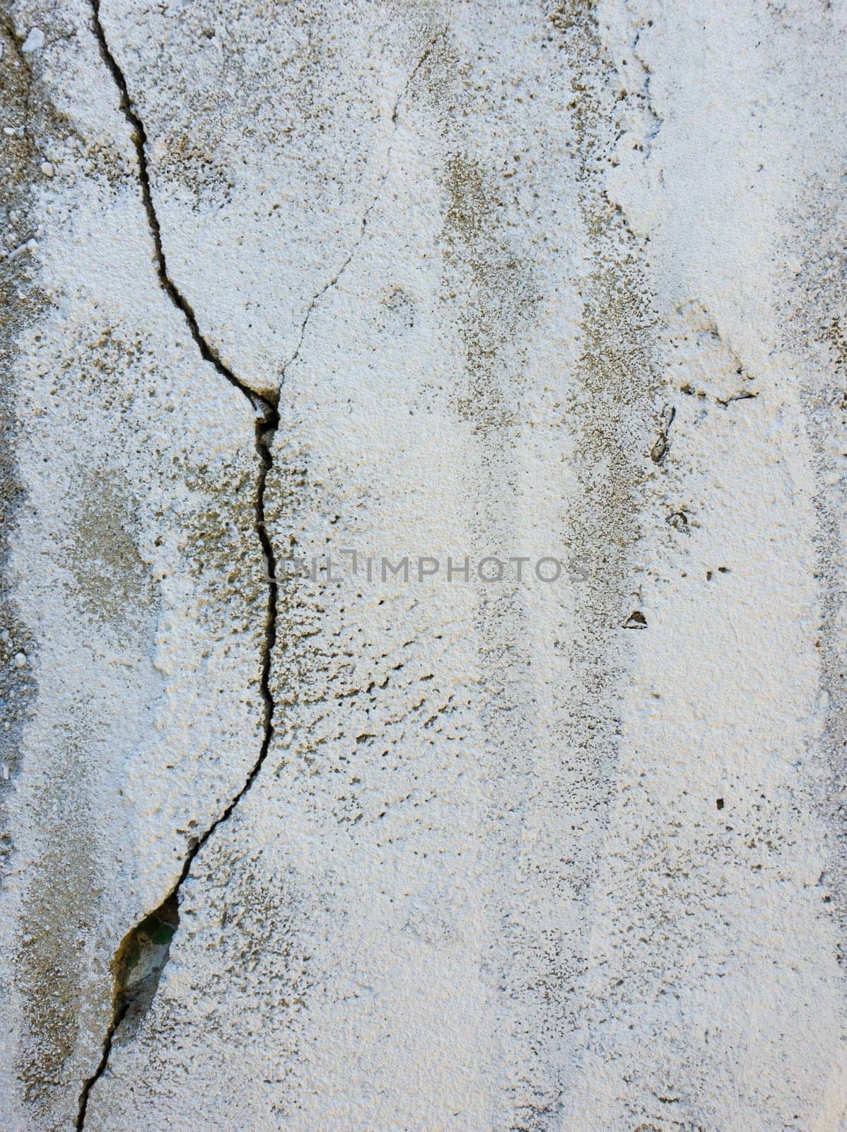 Old grungy, weathered concrete wall with big cracks. White beton structure, abstract details of construction element. Dirty texture surface.