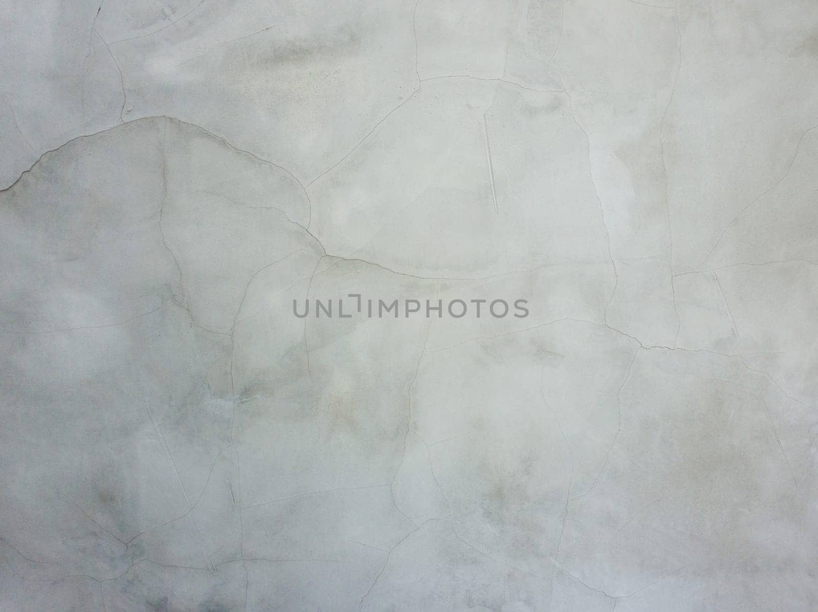 Abstract surface off smooth, grey plaster wall with cracks and scratches. Old grungy, weathered construction structure, dirty texture.