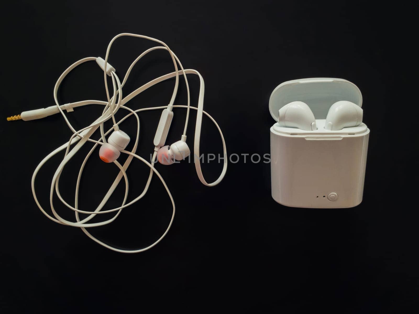 Comparison between tangled wired headphones versus wireless earphones for music listening. Pros and cons, opposite contrary. Technology development tendencies, human entertainment conveniences concept