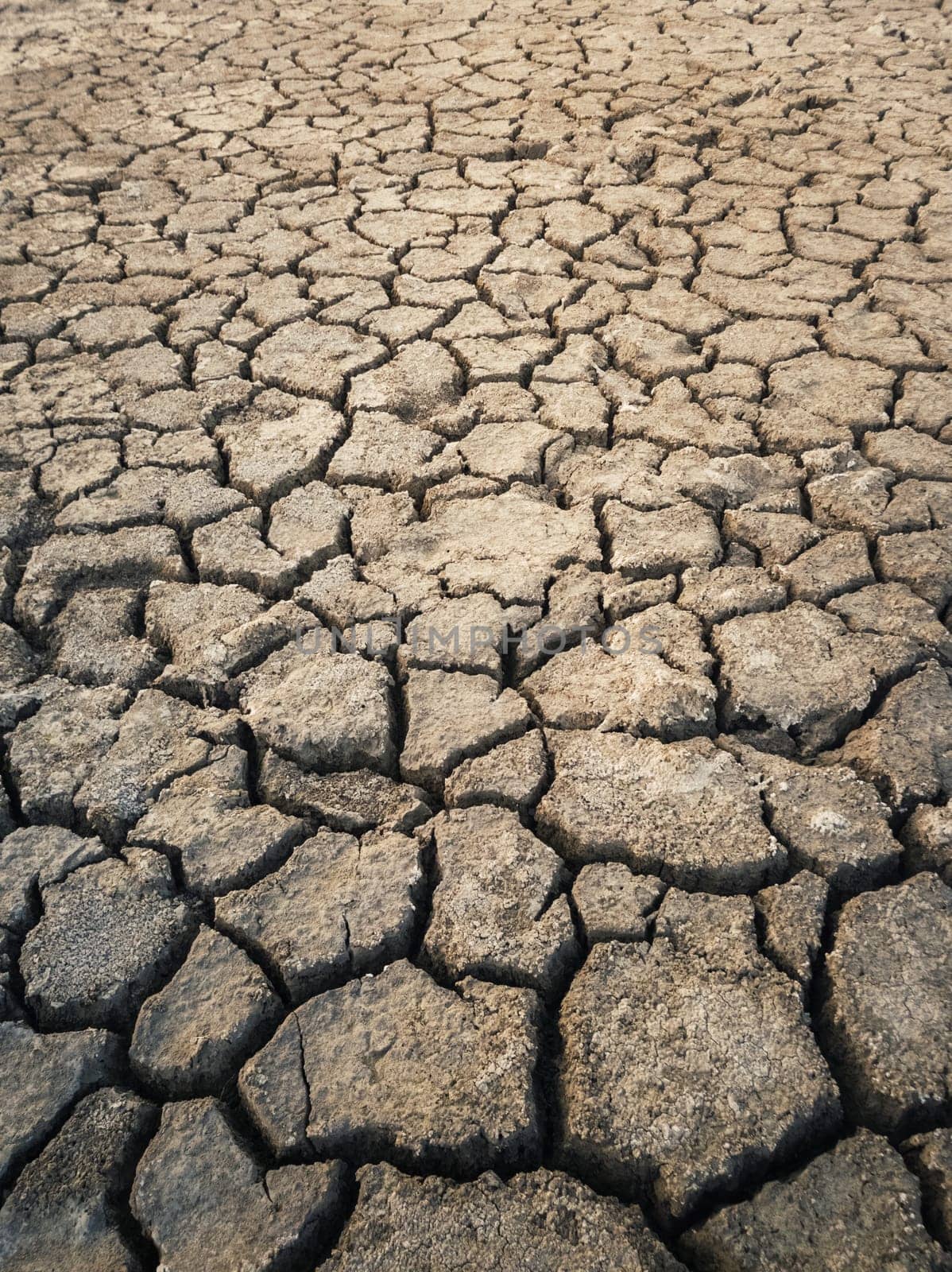 Dry and broken clay ground during drought season, concept of global warming problem. Cracked and barren soil texture background. The global shortage of water on the planet. Arid land, natural disaster