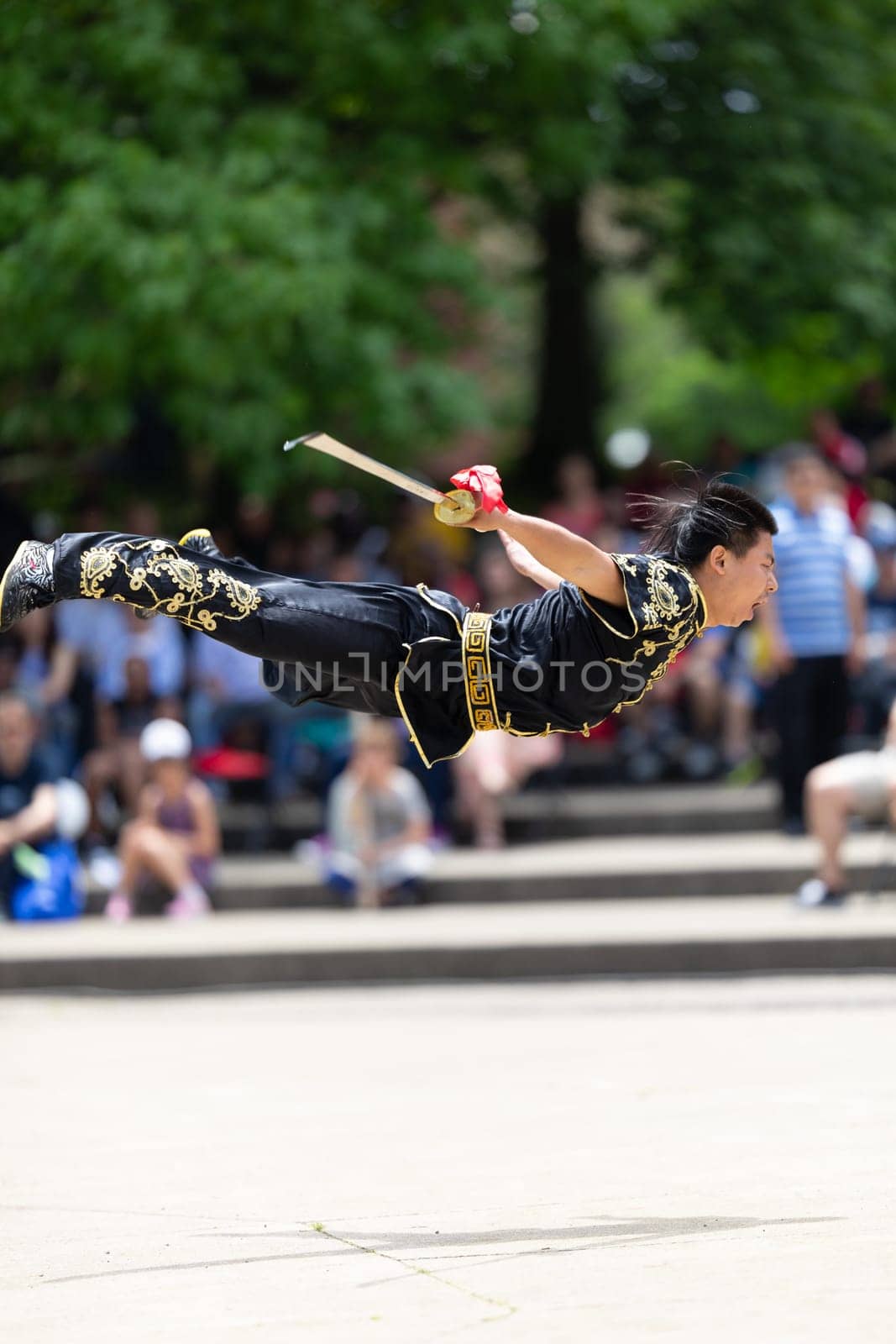 Columbus, Ohio, USA - May 26, 2019: Columbus Asian Festival, Franklin Park, Man wearing traditional chinese clothing handling a Kungfu broadsword during the festival