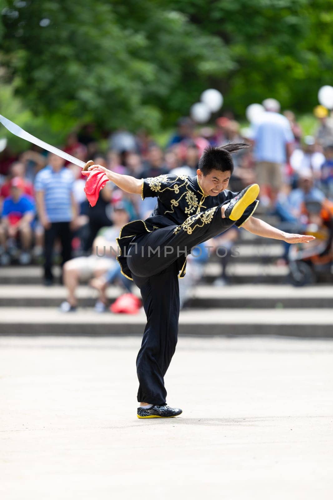 Columbus, Ohio, USA - May 26, 2019: Columbus Asian Festival, Franklin Park, Man wearing traditional chinese clothing handling a Kungfu broadsword during the festival