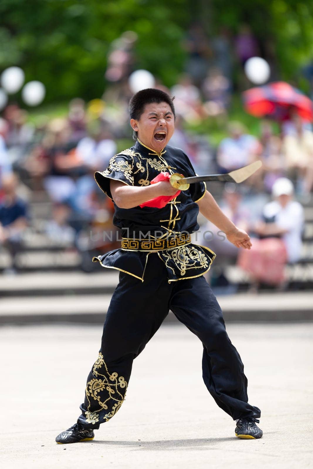 Columbus, Ohio, USA - May 26, 2019: Columbus Asian Festival, Franklin Park, Man wearing traditional chinese clothing handling a Kungfu broadsword during the festival