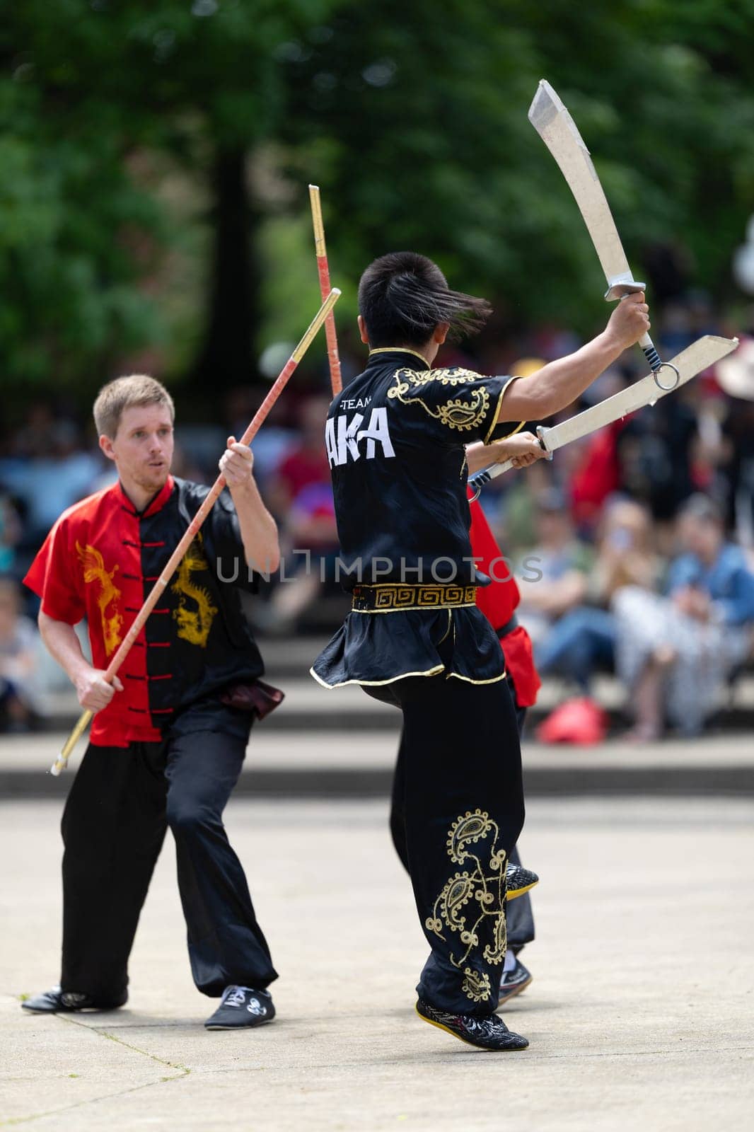 Columbus, Ohio, USA - May 26, 2019: Columbus Asian Festival, Franklin Park, Man using double Duilian Broadswords, fighting two men with Sticks