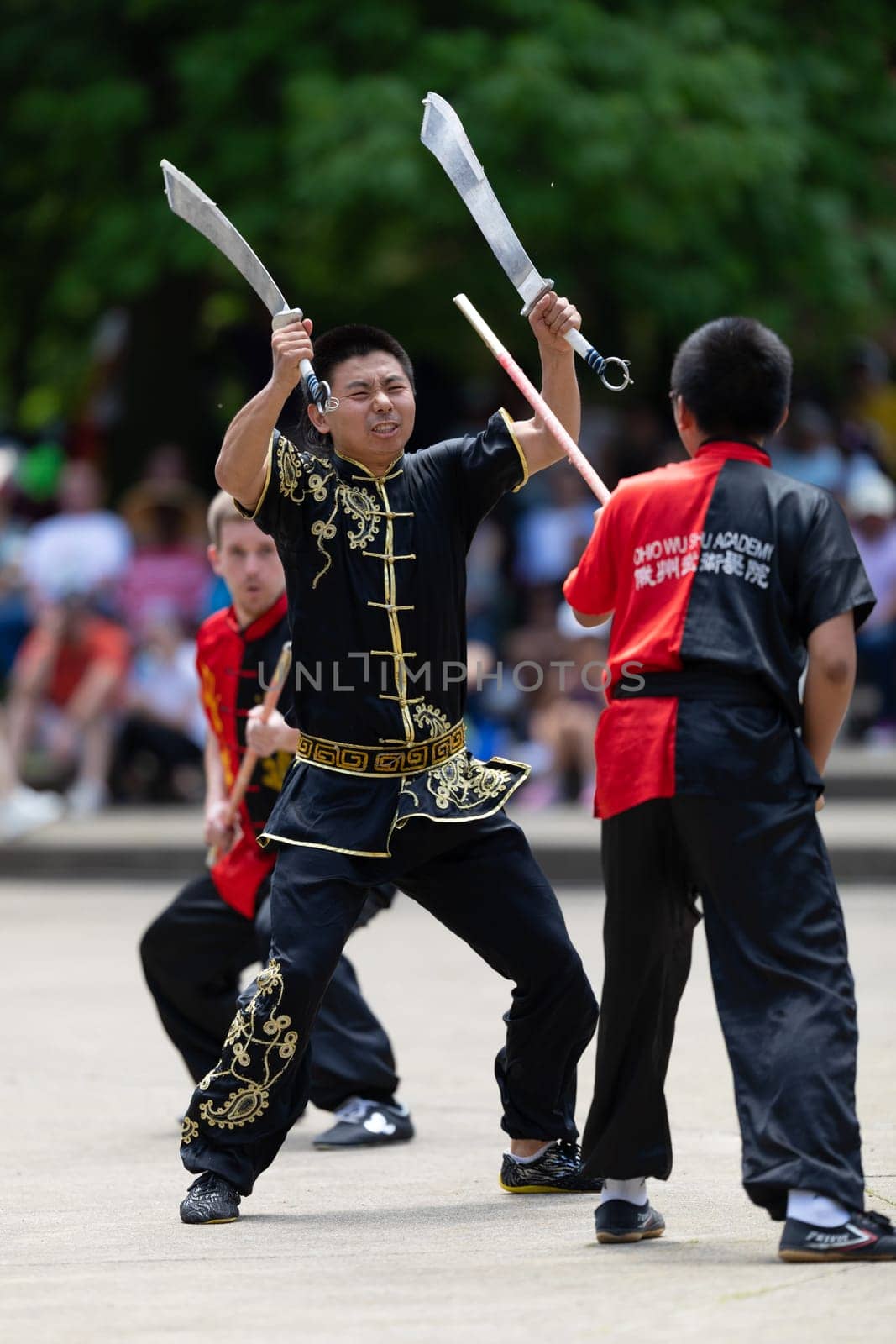 Columbus, Ohio, USA - May 26, 2019: Columbus Asian Festival, Franklin Park, Man using double Duilian Broadswords, fighting two men with Sticks