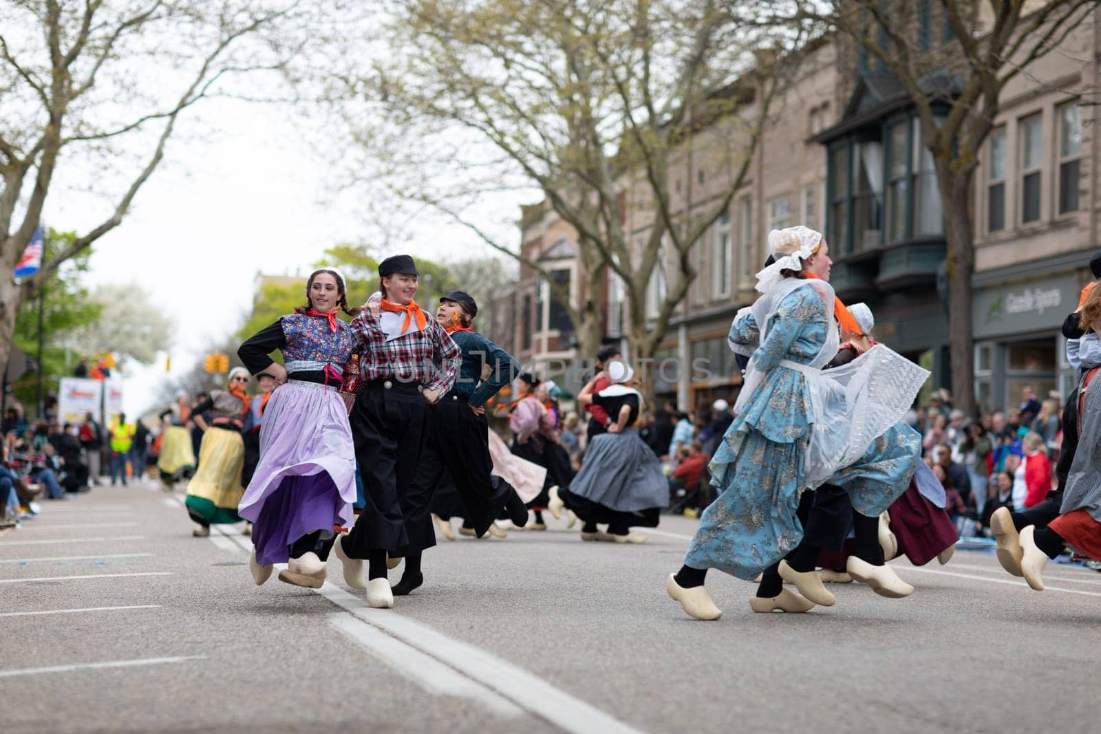 Holland, Michigan, USA - May 11, 2019: Tulip Time Festival, Young women wearing traditional Dutch Clothing dancing in the streets of Holland, Michigan during the Festival