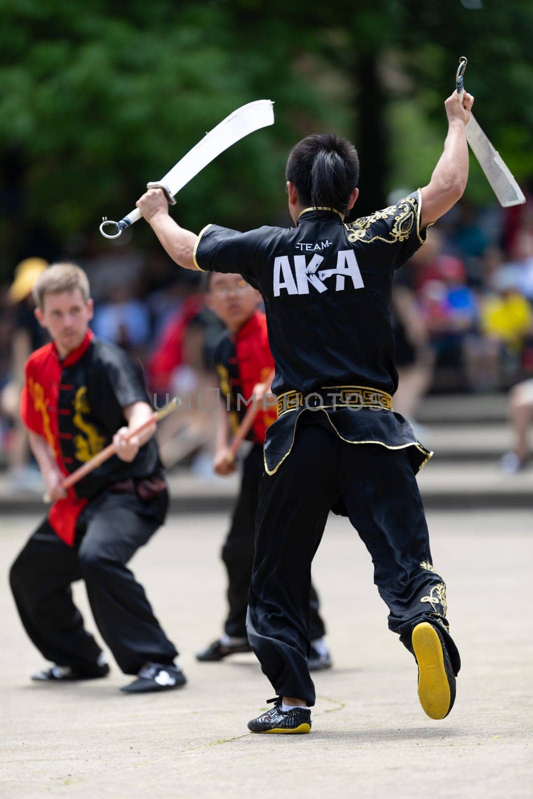 Columbus, Ohio, USA - May 26, 2019: Columbus Asian Festival, Franklin Park, Man using double Duilian Broadswords, fighting two men with Sticks