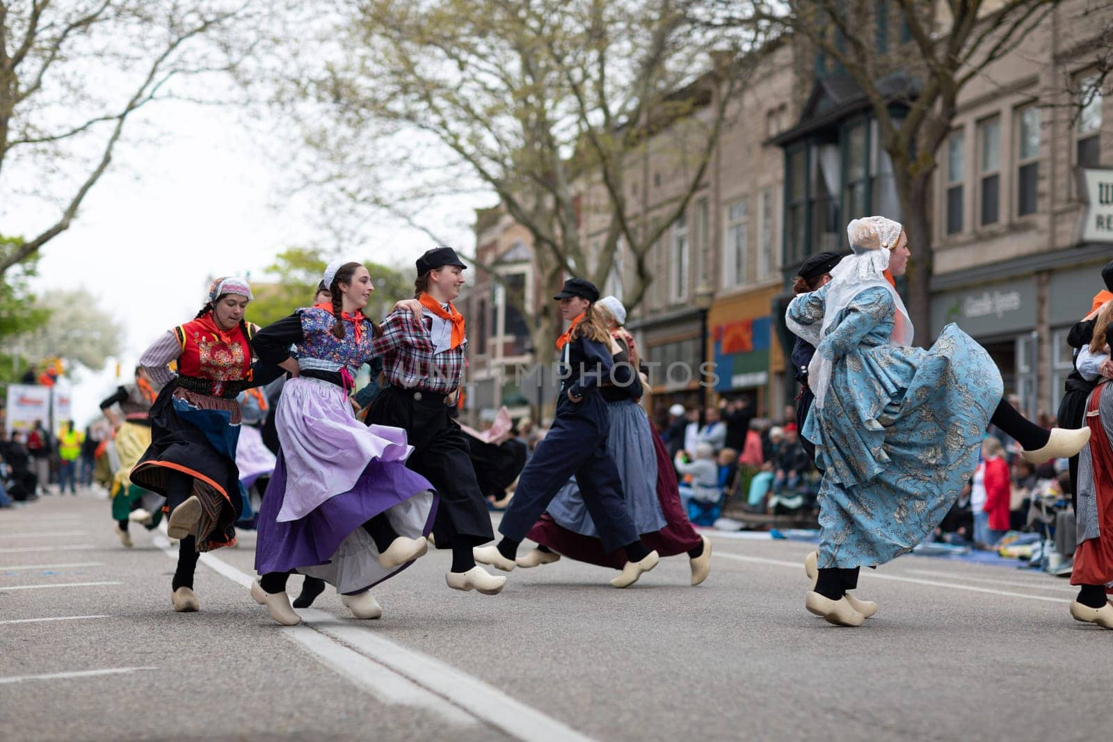 Holland, Michigan, USA - May 11, 2019: Tulip Time Festival, Young women wearing traditional Dutch Clothing dancing in the streets of Holland, Michigan during the Festival