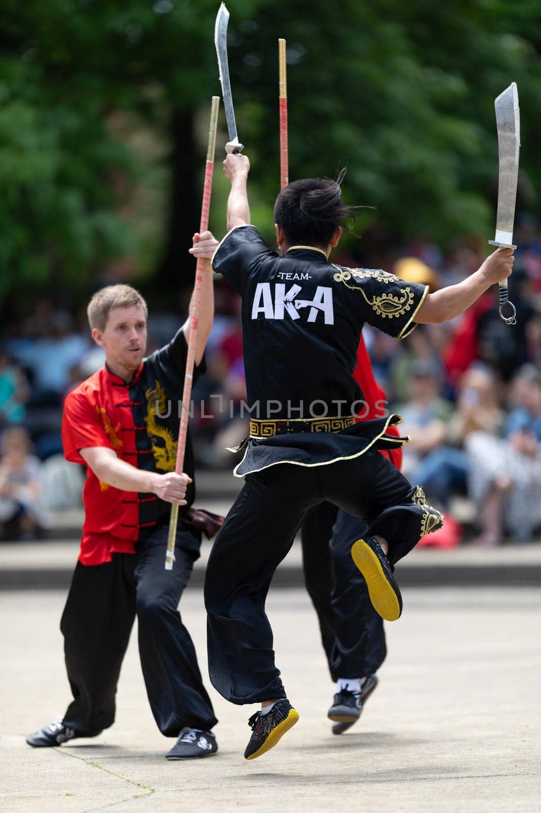 Columbus, Ohio, USA - May 26, 2019: Columbus Asian Festival, Franklin Park, Man using double Duilian Broadswords, fighting two men with Sticks