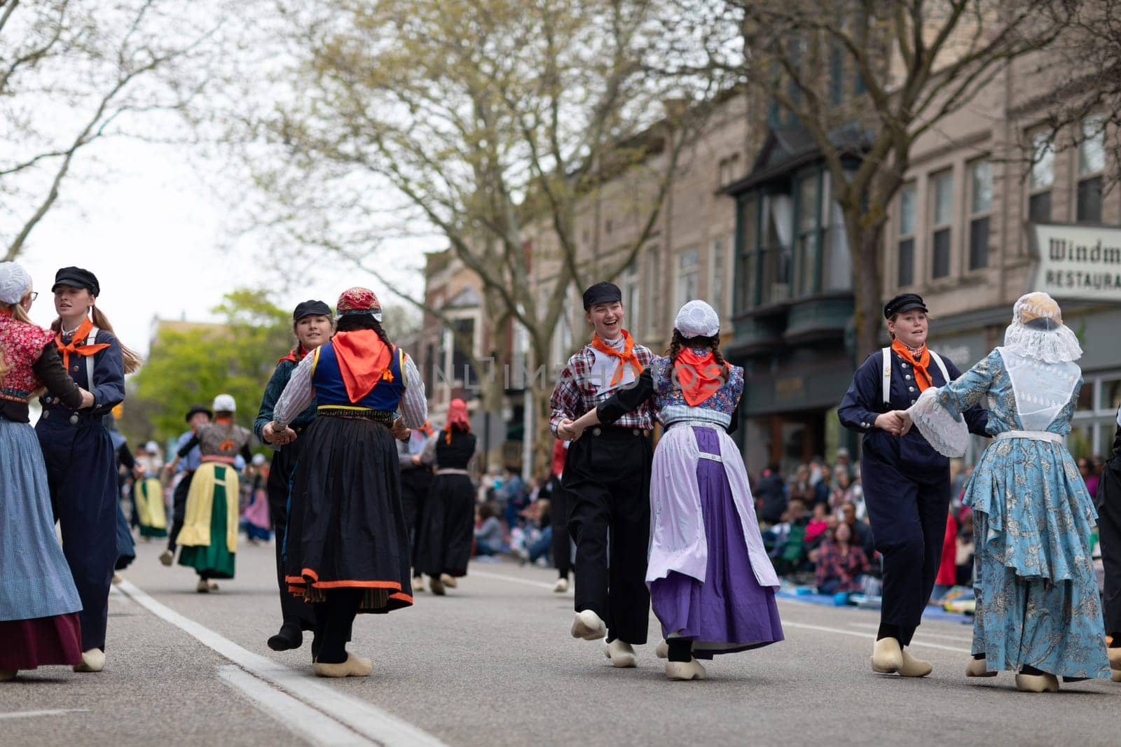 Holland, Michigan, USA - May 11, 2019: Tulip Time Festival, Young women wearing traditional Dutch Clothing dancing in the streets of Holland, Michigan during the Festival