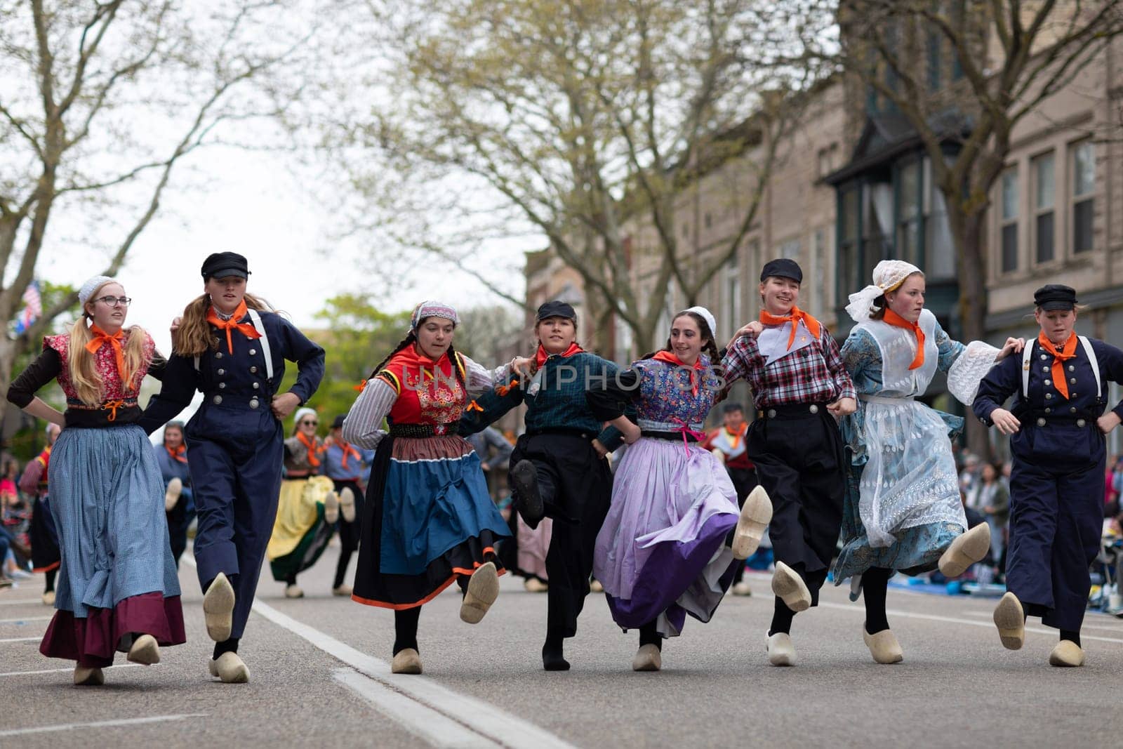 Holland, Michigan, USA - May 11, 2019: Tulip Time Festival, Young women wearing traditional Dutch Clothing dancing in the streets of Holland, Michigan during the Festival