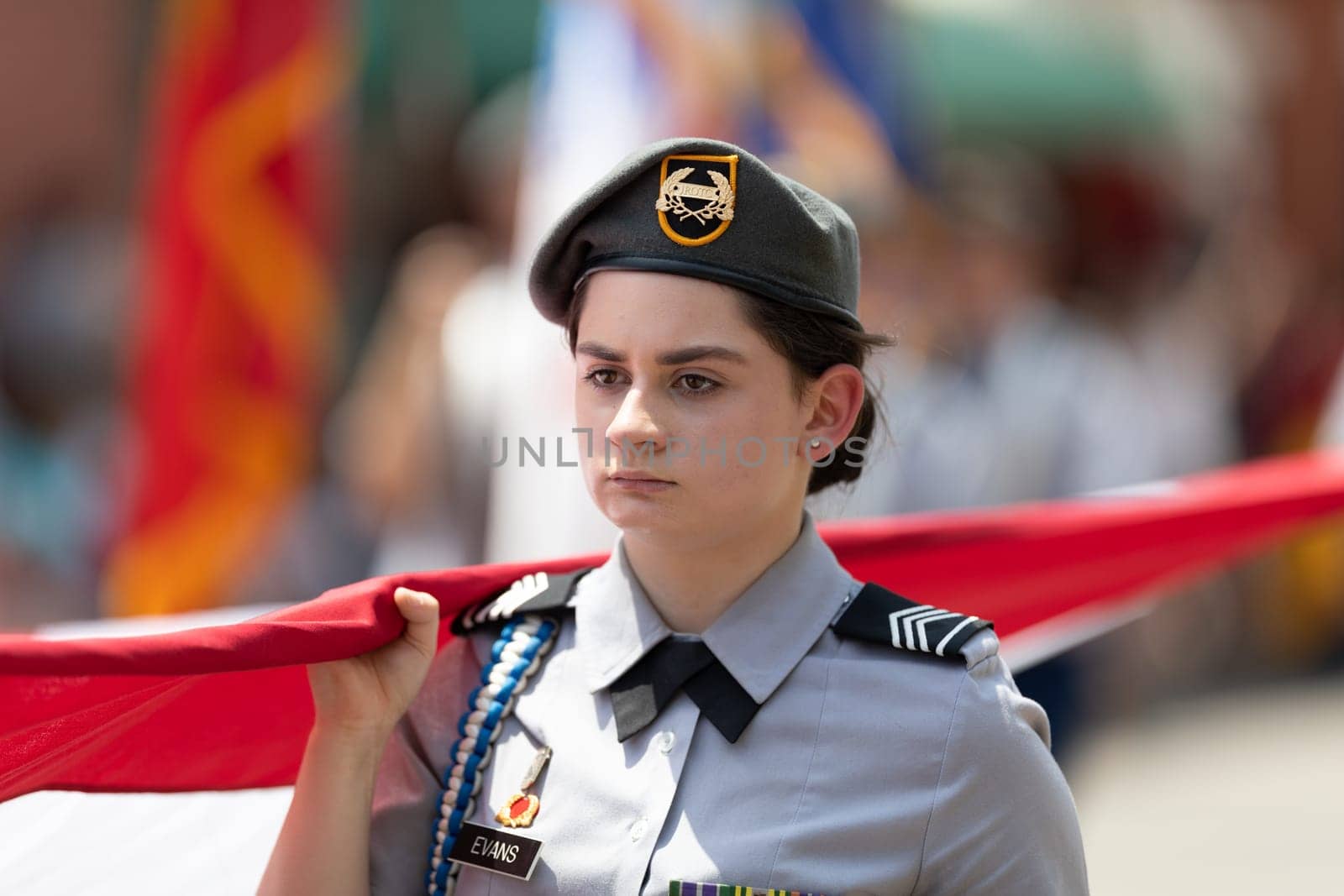 Buckhannon, West Virginia, USA - May 18, 2019: Strawberry Festival, Youg woman, member of the JROTC, wearing military Uniform, carrying a large American flag down Main Street