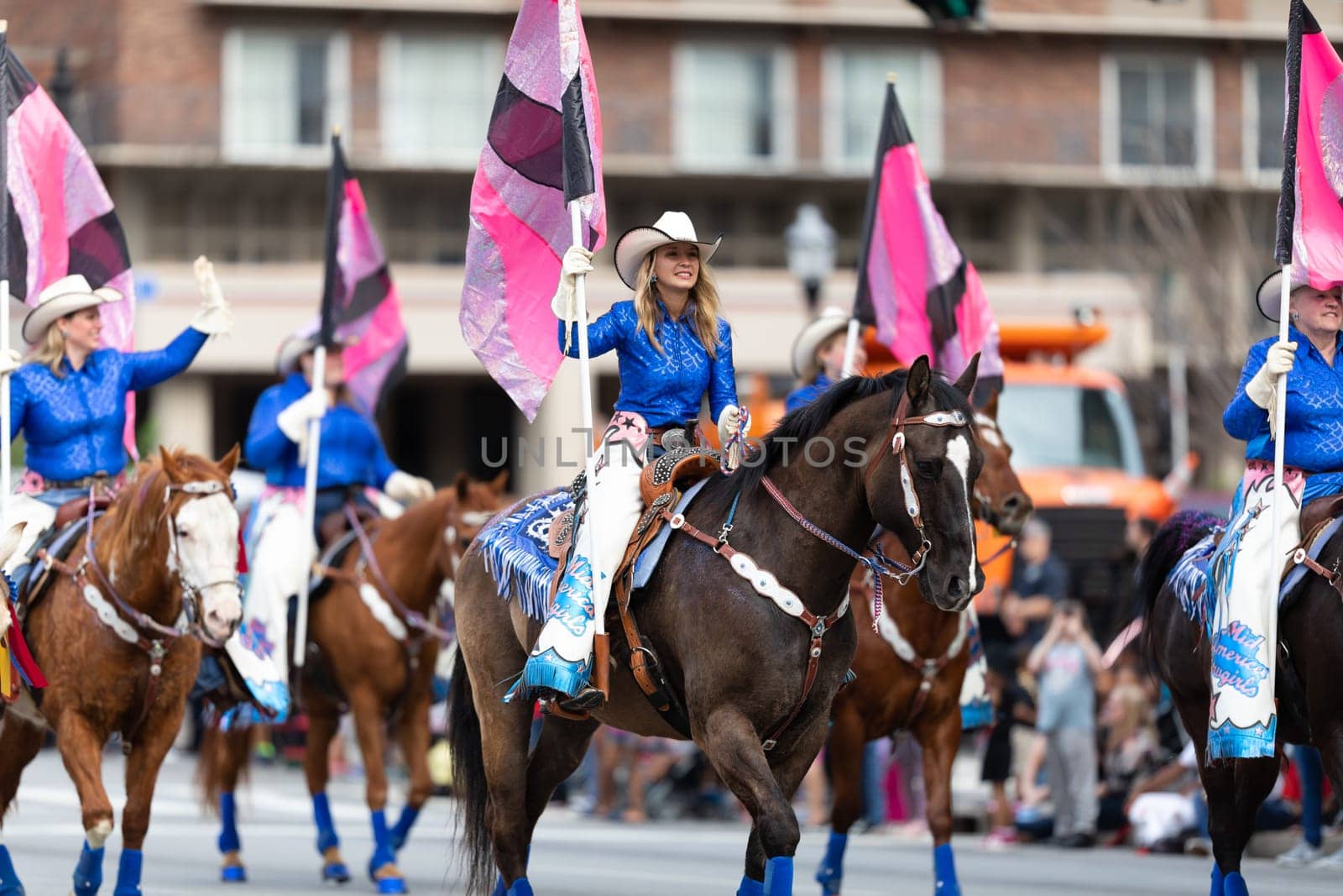 Louisville, Kentucky, USA - May 2, 2019: The Pegasus Parade, The Mid America Cowgirls riding horses and carrying flags during the parade