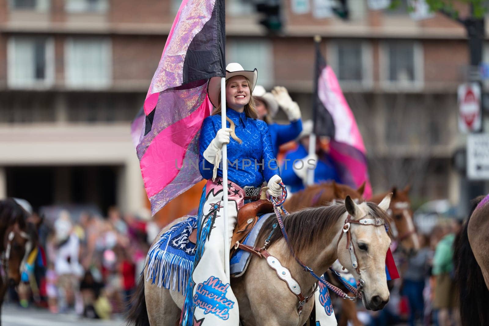 Louisville, Kentucky, USA - May 2, 2019: The Pegasus Parade, The Mid America Cowgirls riding horses and carrying flags during the parade