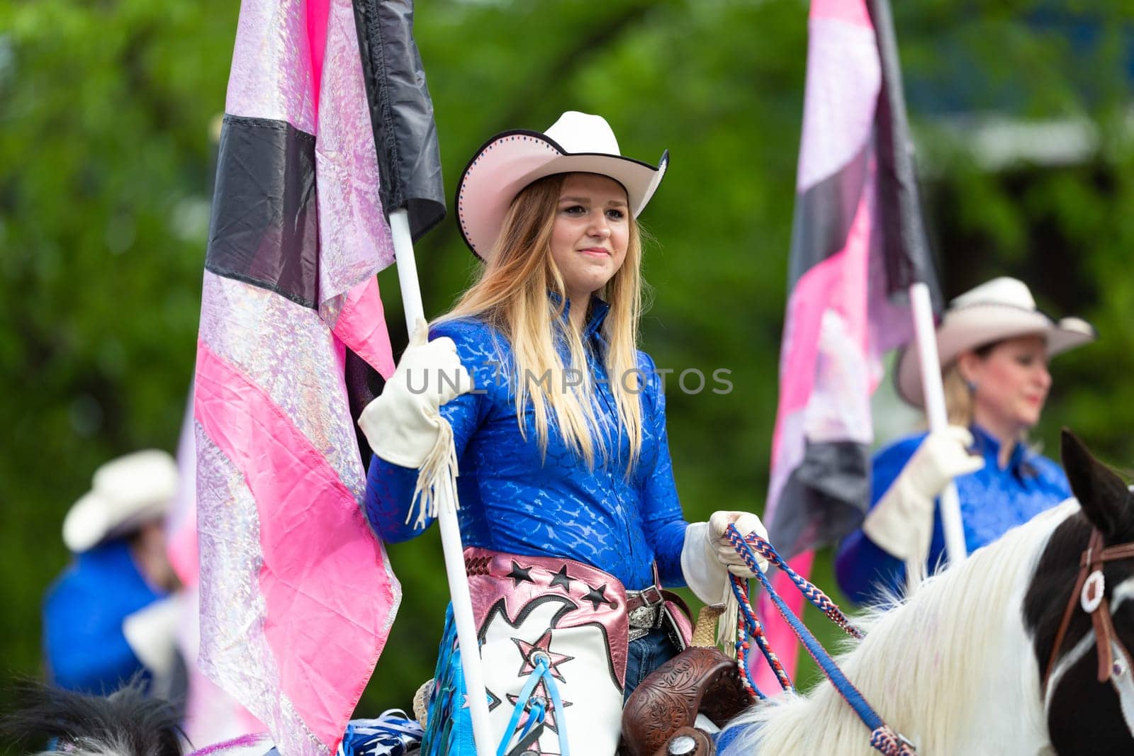 Louisville, Kentucky, USA - May 2, 2019: The Pegasus Parade, The Mid America Cowgirls riding horses and carrying flags during the parade