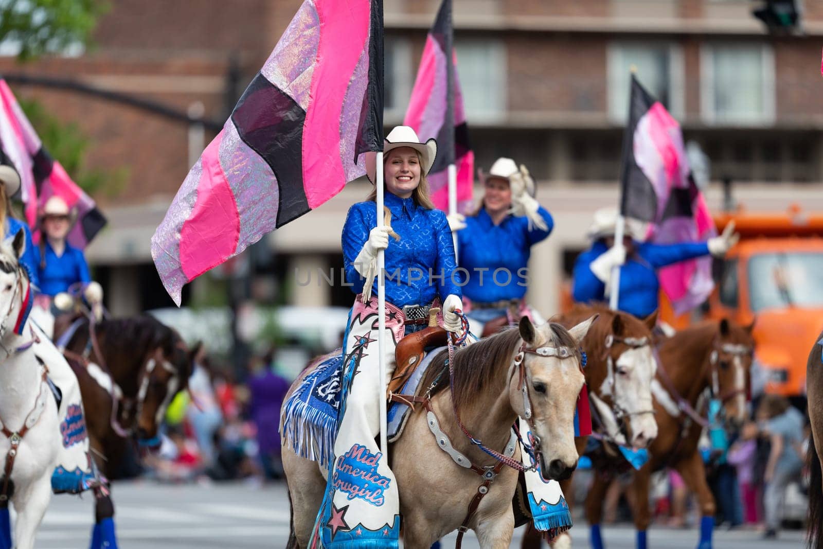 Louisville, Kentucky, USA - May 2, 2019: The Pegasus Parade, The Mid America Cowgirls riding horses and carrying flags during the parade