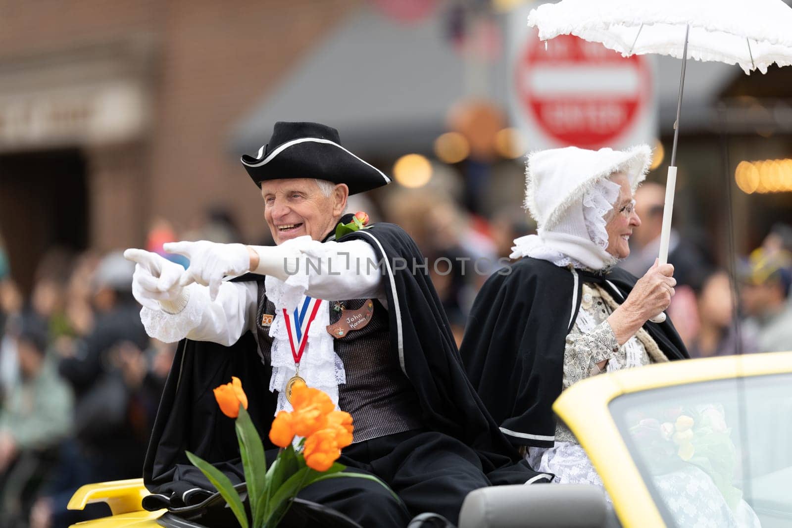 Holland, Michigan, USA - May 11, 2019: Tulip Time Parade, Man and woman wearing traditional dutch clothing going down the street during the parade