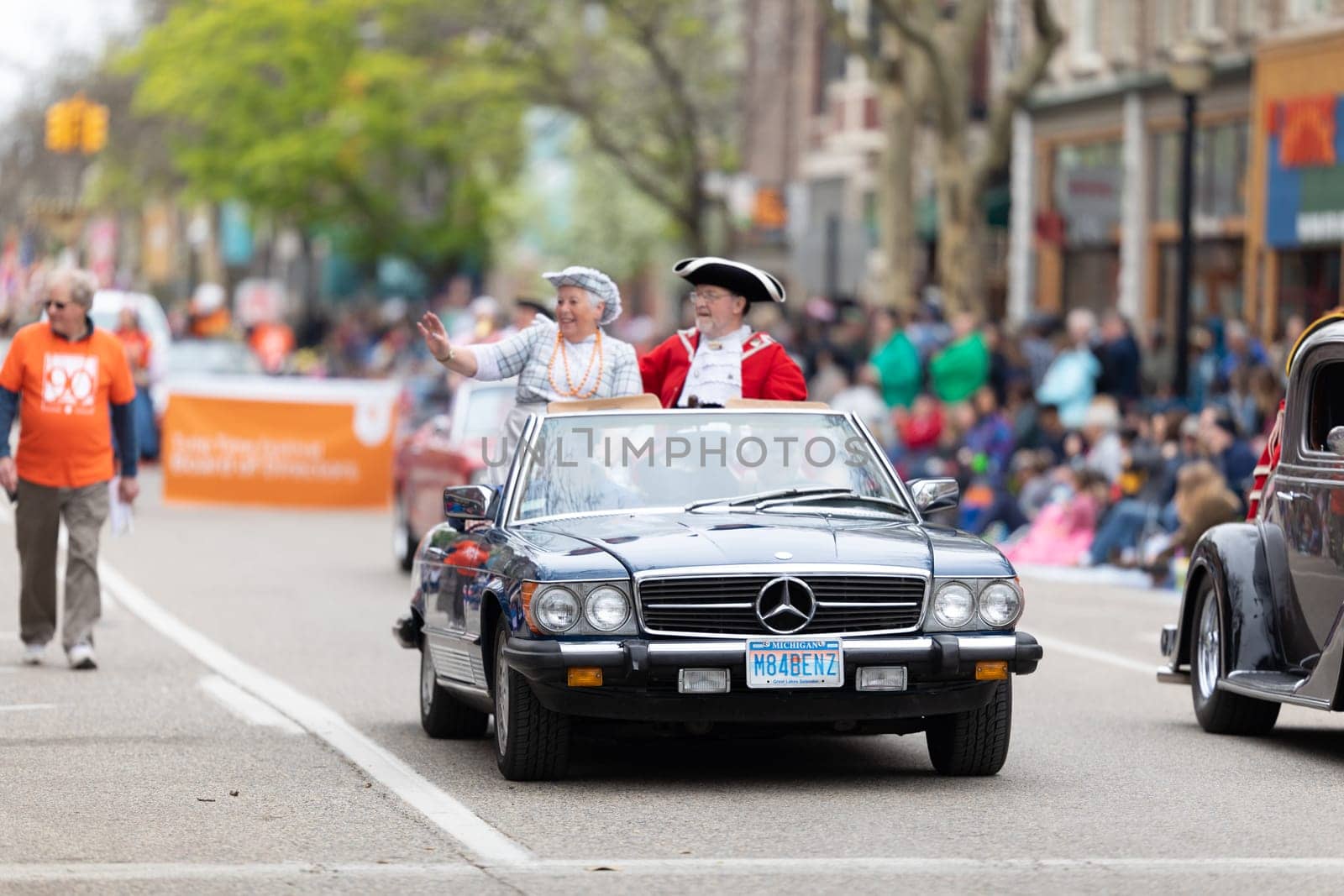 Holland, Michigan, USA - May 11, 2019: Tulip Time Parade, Man and woman wearing traditional dutch clothing riding on a Mercedez during the parade