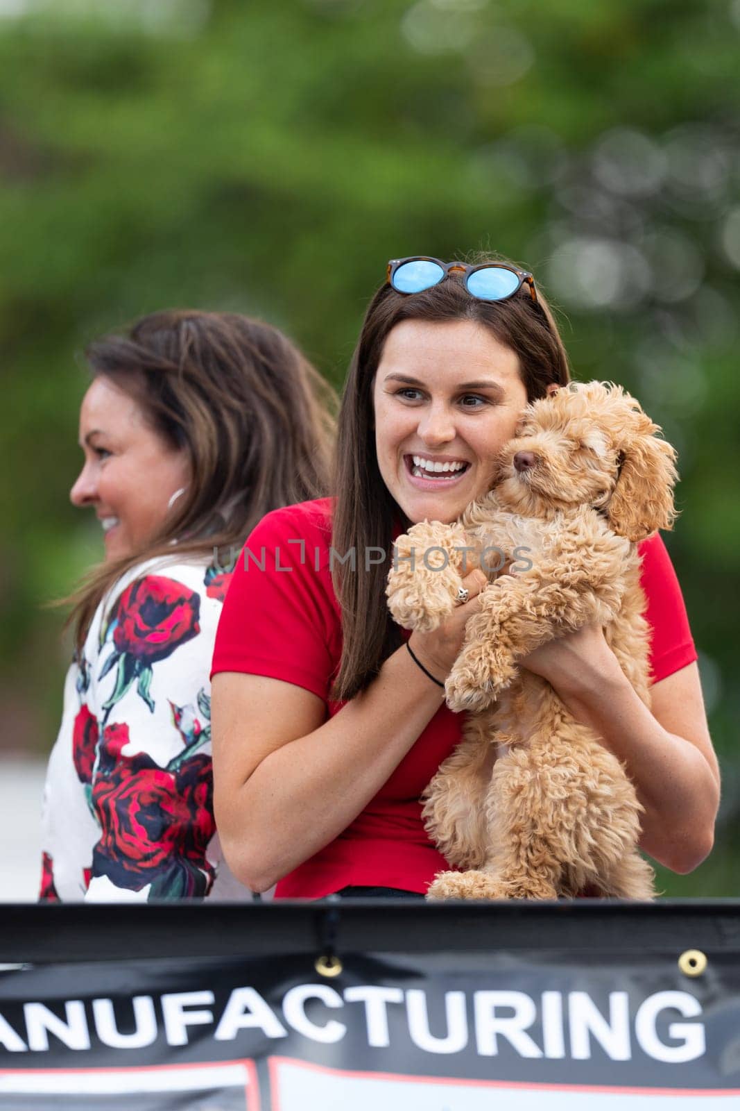 Louisville, Kentucky, USA - May 2, 2019: The Pegasus Parade, young woman huging her pet dog, smiling, during the parade