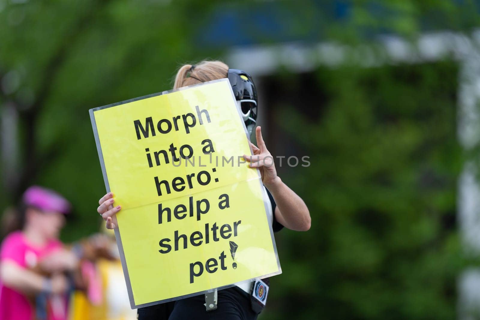 Louisville, Kentucky, USA - May 2, 2019: The Pegasus Parade, Woman holding a sign that says, Morph into a Hero: Help a shelter pet, promoting pet adoption during the parade
