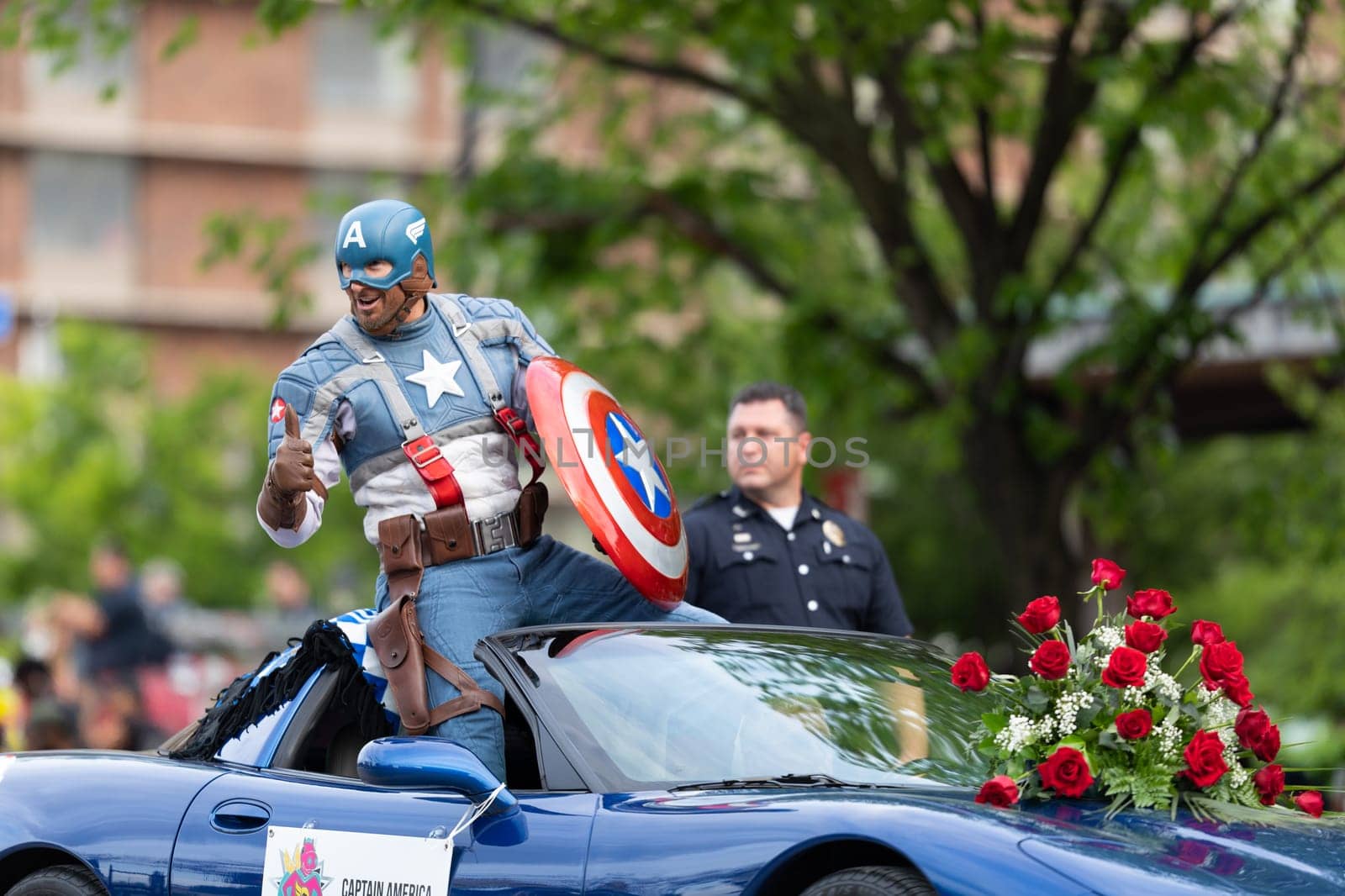 Louisville, Kentucky, USA - May 2, 2019: The Pegasus Parade, man dress up as captain america, riding on a car during the parade