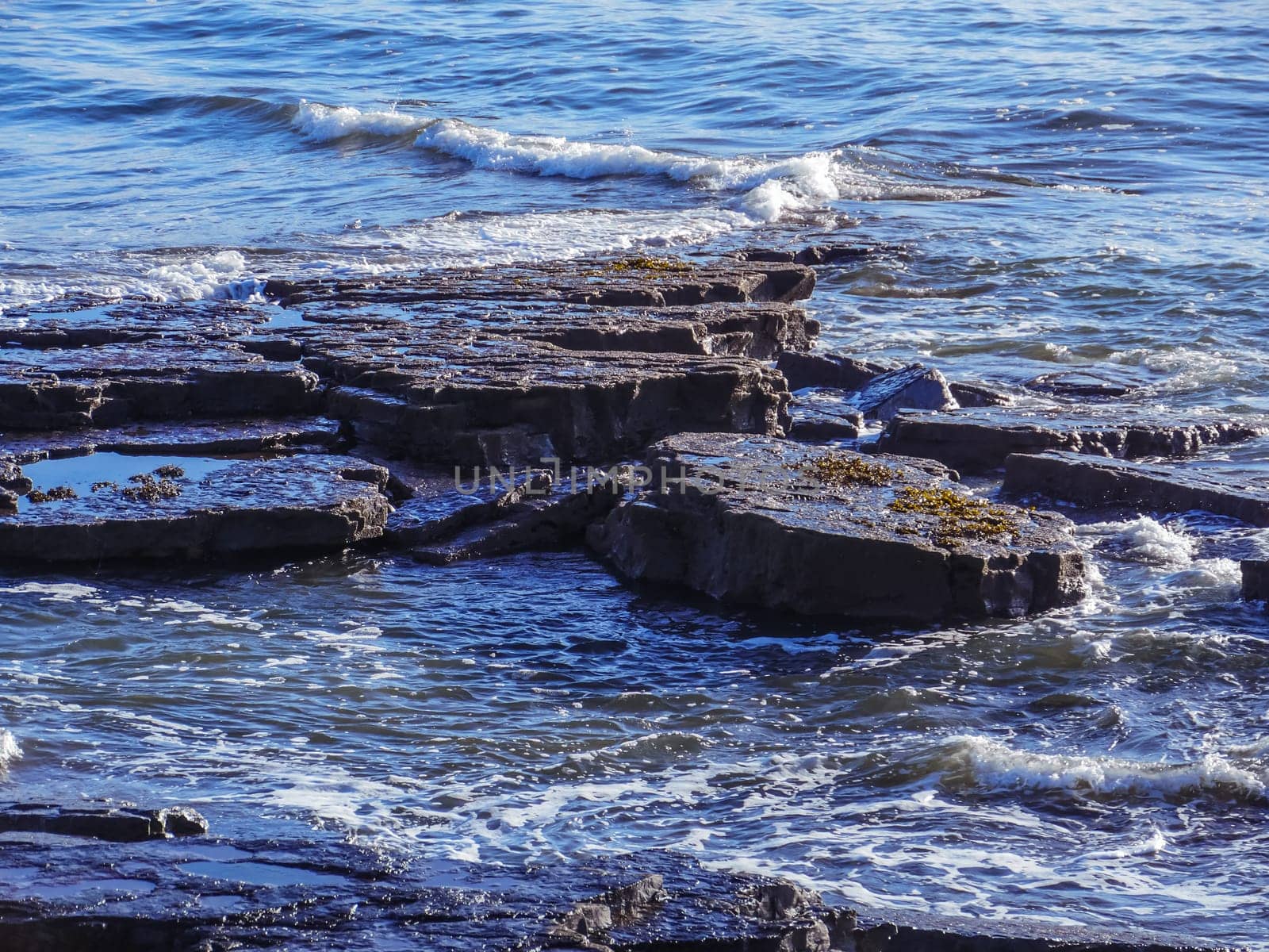 Sea waves lash line impact rock on the ocean beach