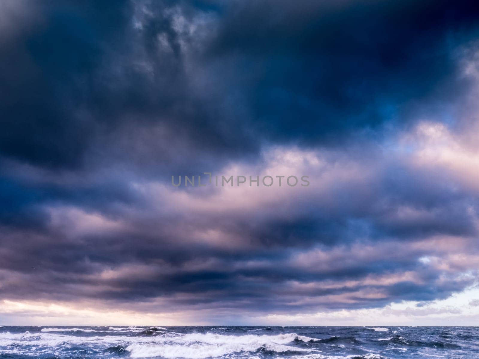 Baltic sea beach with blue cloudy sky and waves
