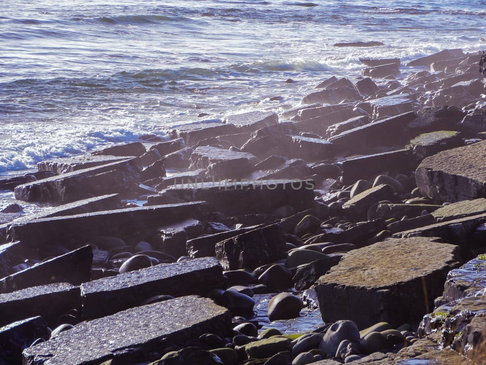 Sea waves lash line impact rock on the ocean beach