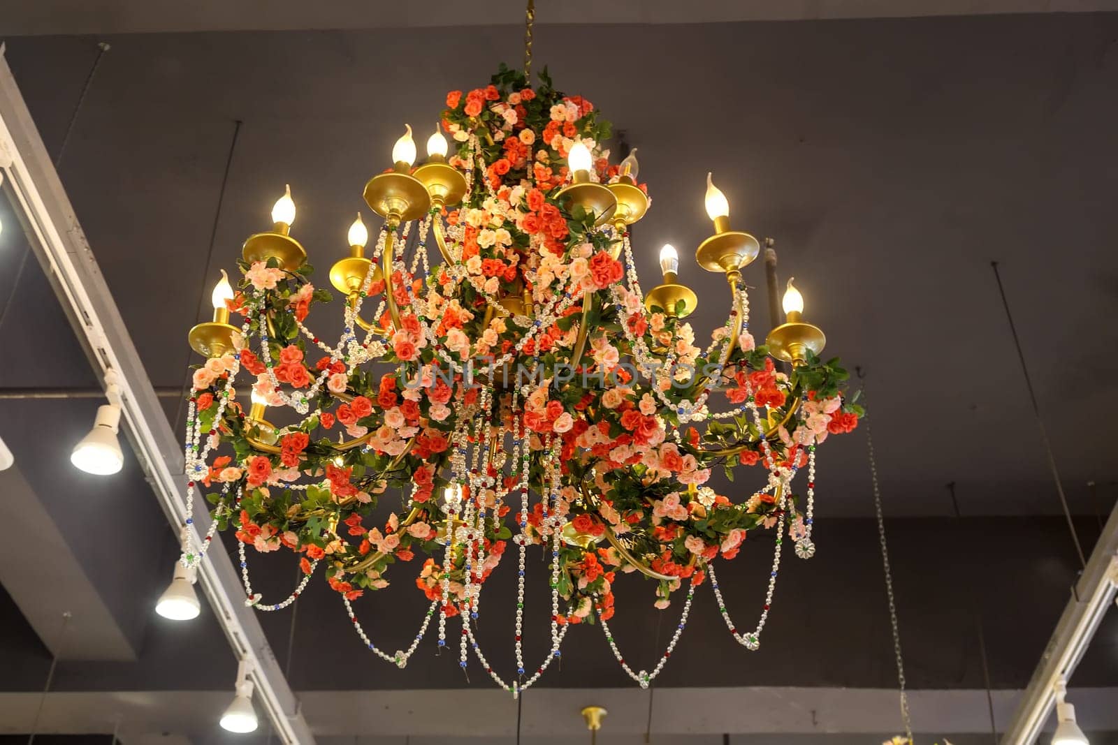 Chandelier decorated with artificial flowers and beads in a Chinese cafe