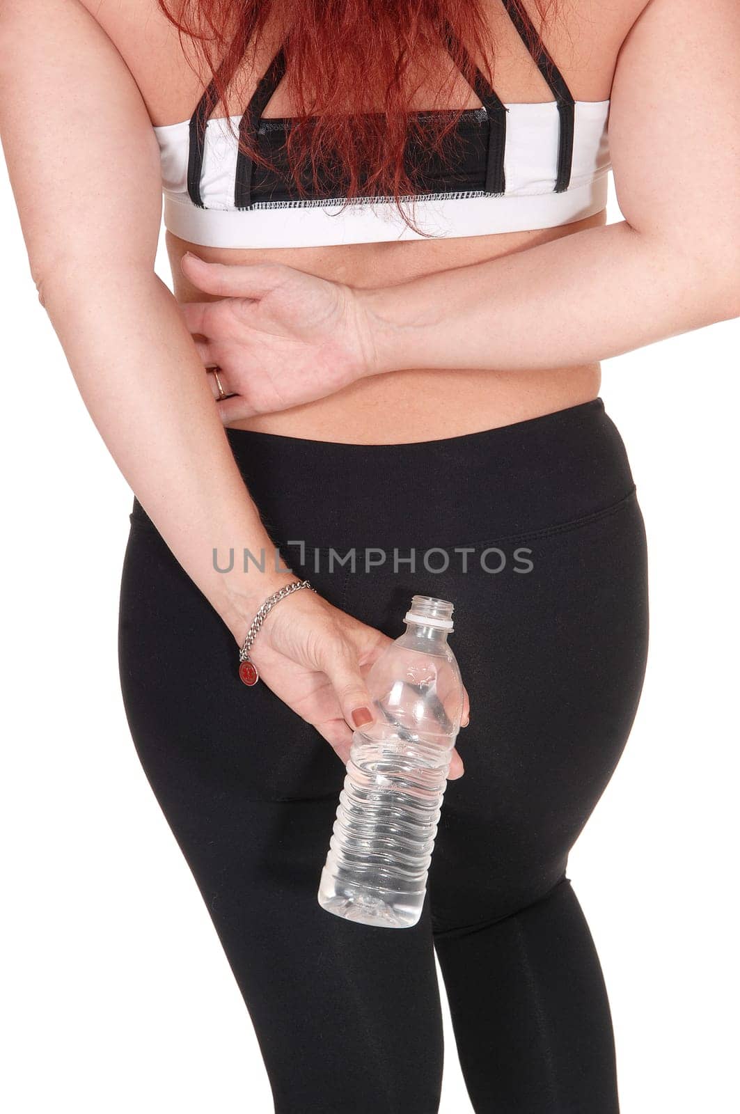A body part image of a woman in exercise outfit standing from the .back holding a water bottle in her hand, isolated for white background.
