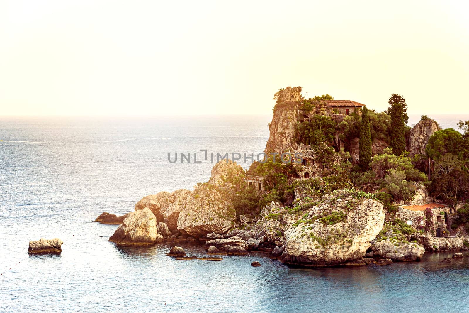 Isola bella islet in the bay of Taormina in Sicily at sunset. Sea and summer season. Tourist destination in Italy