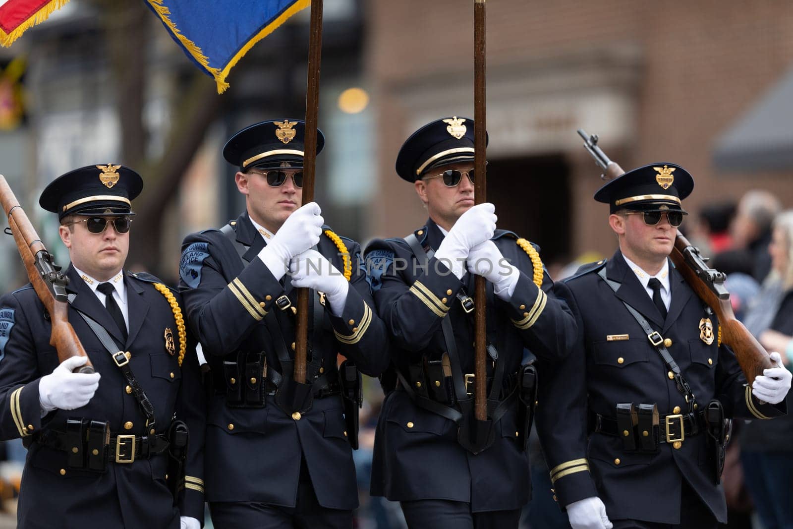 Holland, Michigan, USA - May 11, 2019: Tulip Time Parade, Members of the Holland Police Force, carrying the American flag, marching , during the parade