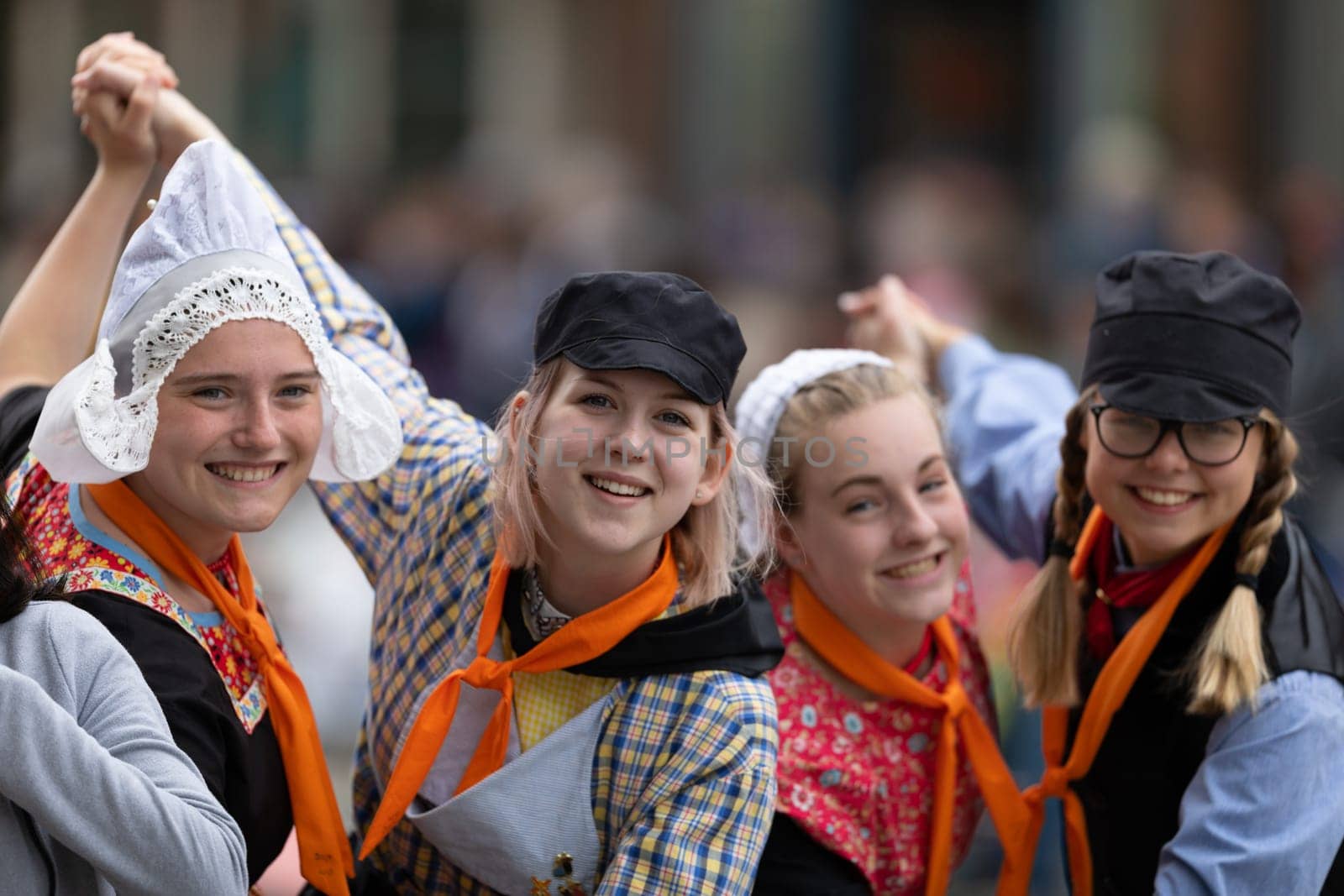 Holland, Michigan, USA - May 11, 2019: Tulip Time Festival, Young women wearing traditional Dutch Clothing dancers in the streets of Holland, Michigan posing for a photo during the Festival