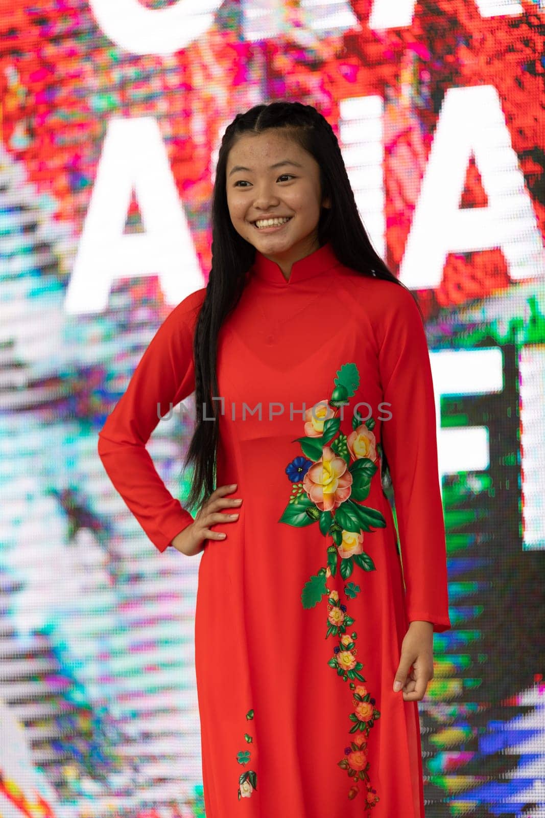 Grand Rapids, Michigan, USA - June 15, 2019: Asian Pacific Festival, Vietnamese woman wearing traditional clothing at a fashion display  in the Rosa Parks Circle