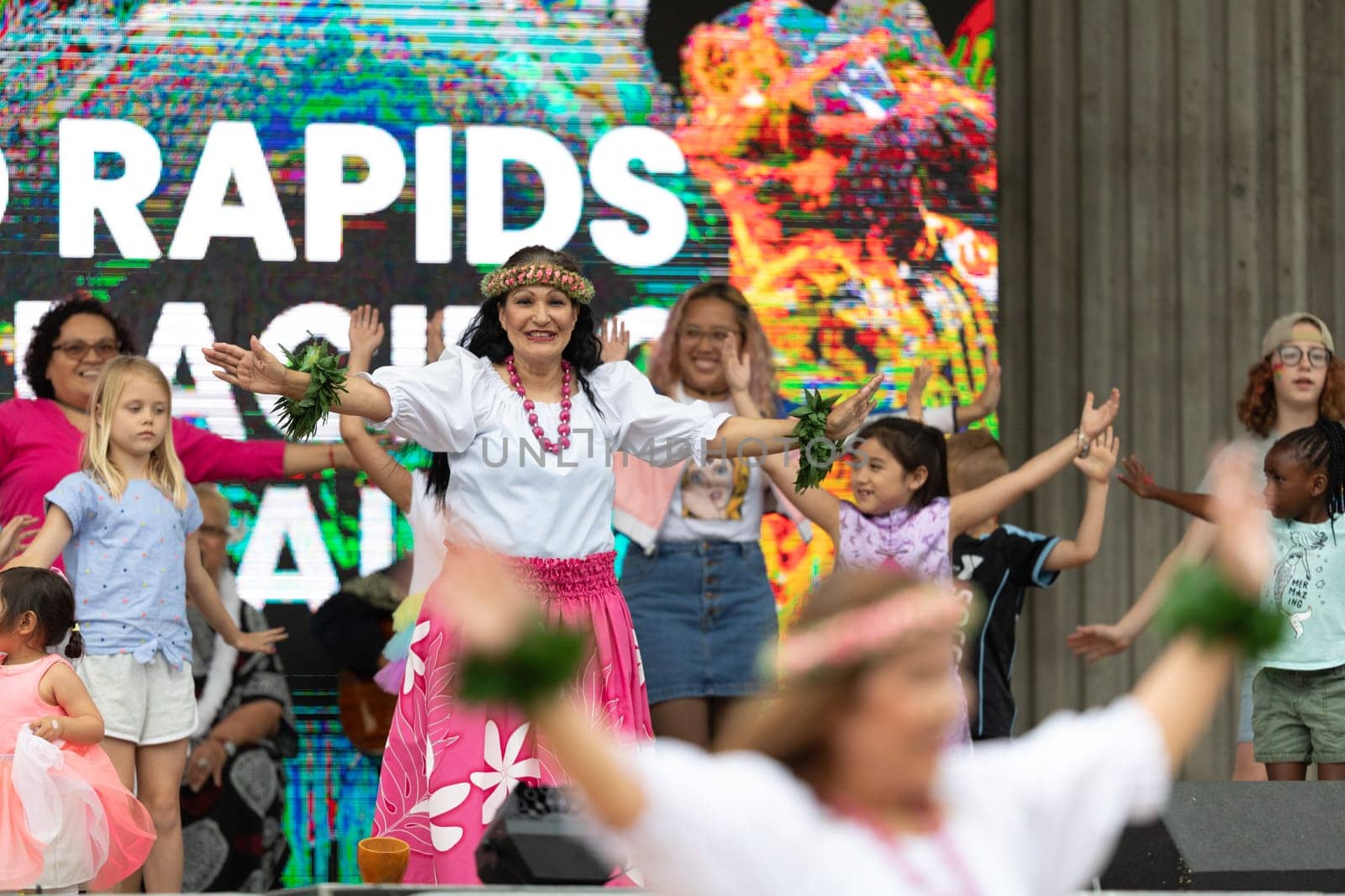 Grand Rapids, Michigan, USA - June 15, 2019: Asian Pacific Festival, Woman wearing traditional clothing performing a hula dance at the Rosa Parks Circle