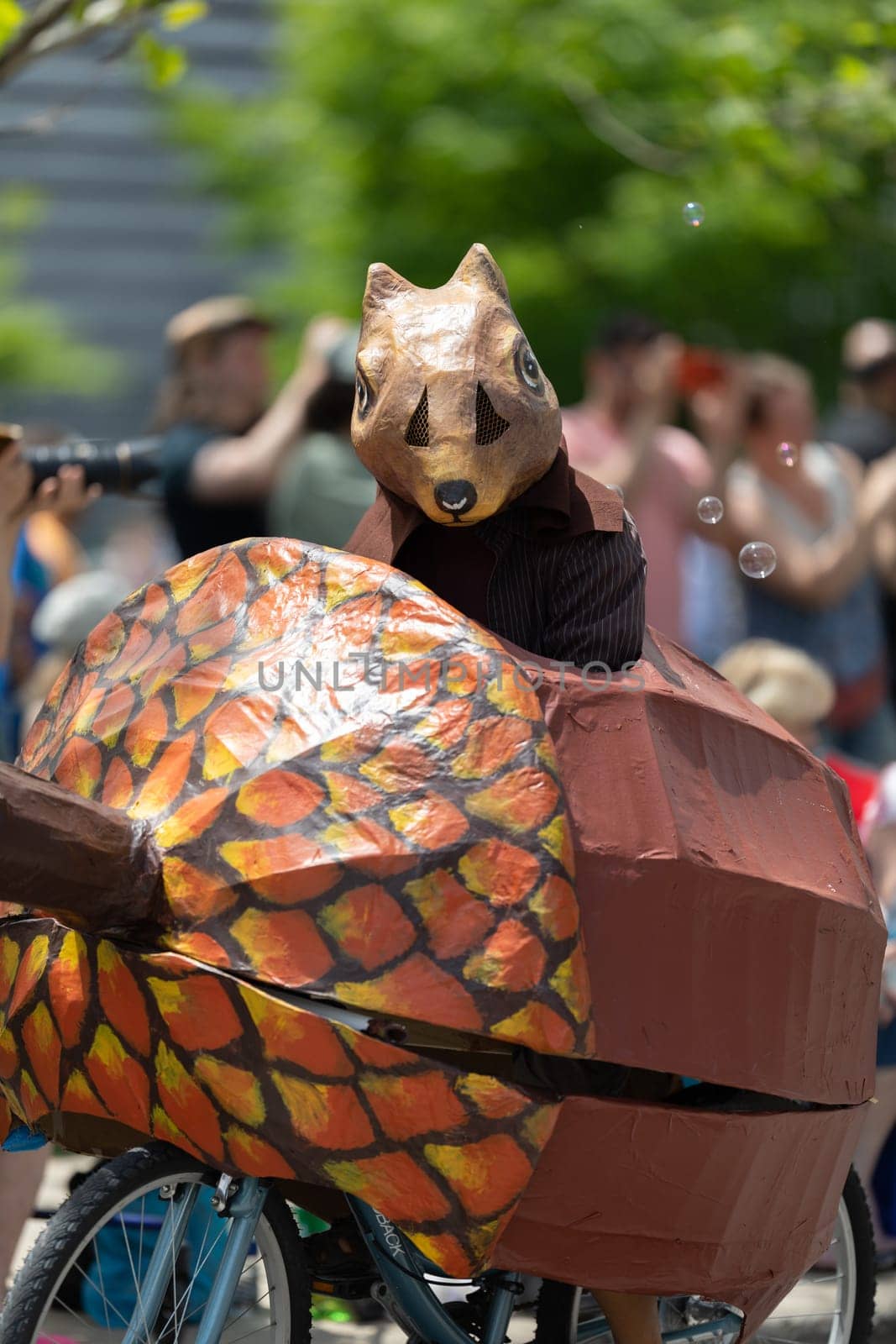 Cleveland, Ohio, USA - June 8, 2019: Parade the Circle, Person wearing a squirrel outfit riding a bicycle in shape of a nut