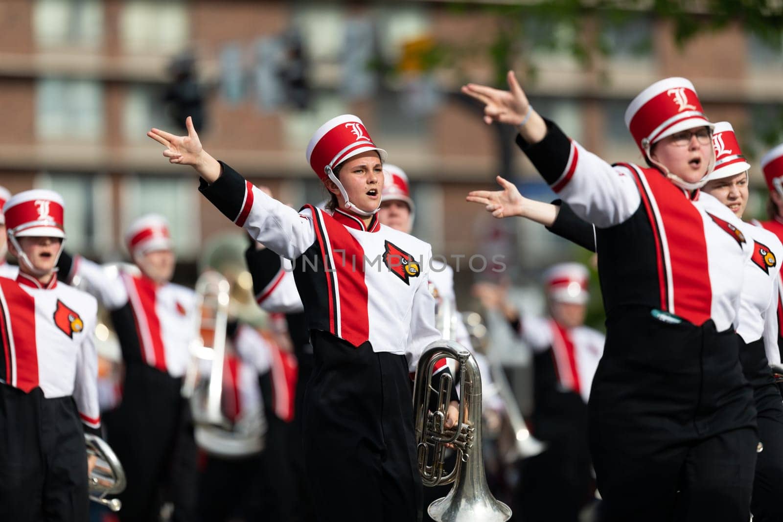 Louisville, Kentucky, USA - May 2, 2019: The Pegasus Parade, Members of the University of Louisville cheerleaders and marching band performing at the parade