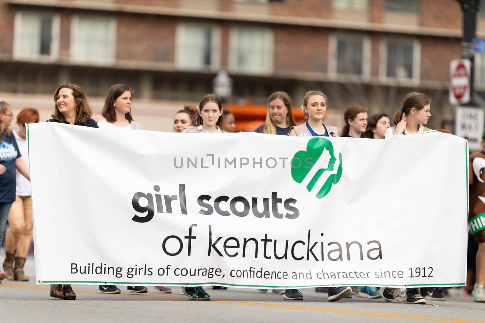 Louisville, Kentucky, USA - May 2, 2019: The Pegasus Parade, Young women carrying a banner promoting the Girl Scouts of Kentuckiana during the parade