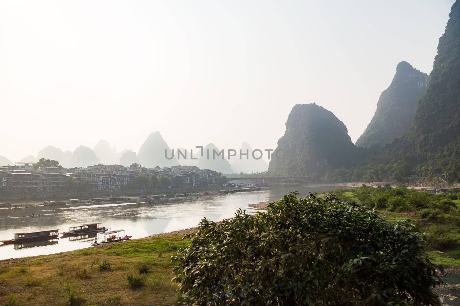Misty sunrise in the mountains of Asia, a village on the banks of the river, Yangshuo China