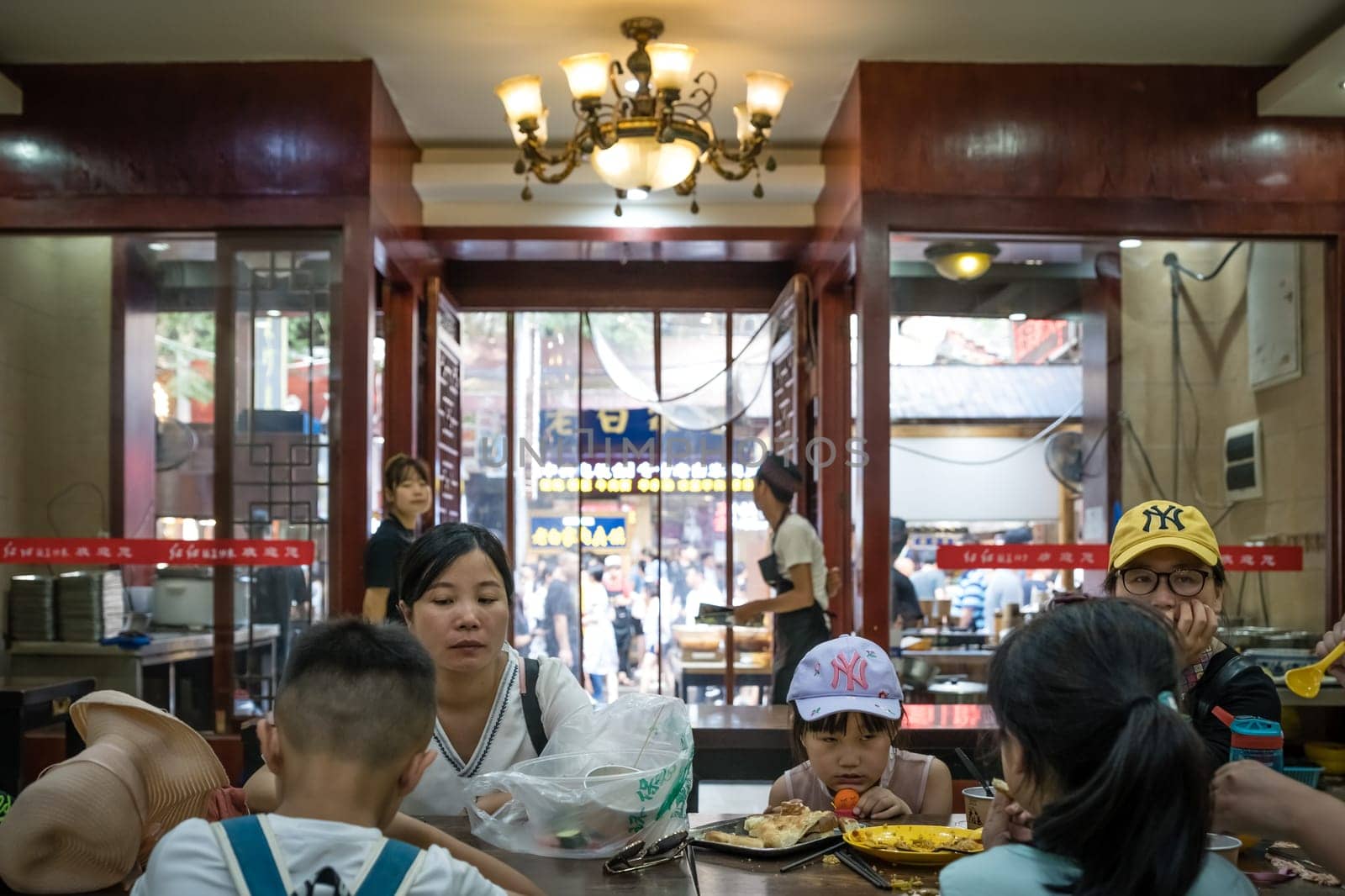 Xian, China -  July 2019 : Chinese family dining in a small local restaurant in the Muslim Quarter