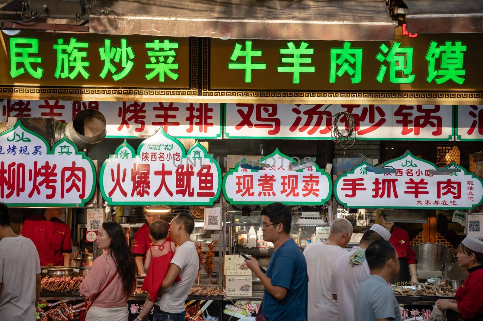 Xian, China -  July 2019 : Colorful and brightly illuminated and lit neons and shop boards in the popular street food district called Muslim Quarter